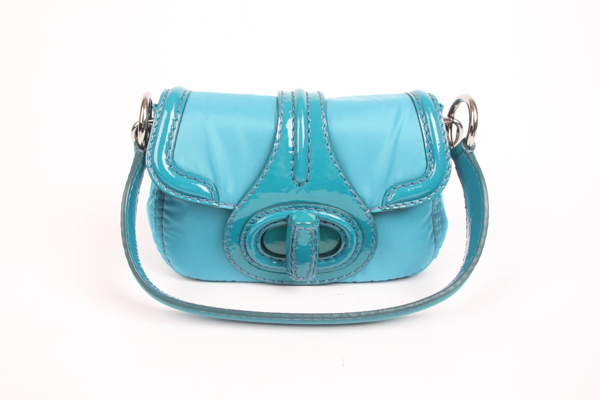 Practical shoulder bag by Prada; this is the Pattina Sottospalla Handbag in turquoise.

Crafted in nylon with patent leather detailing and silver-tone hardware. Large fold-over twist lock closure at the front. A silver-tone logo label inside and on