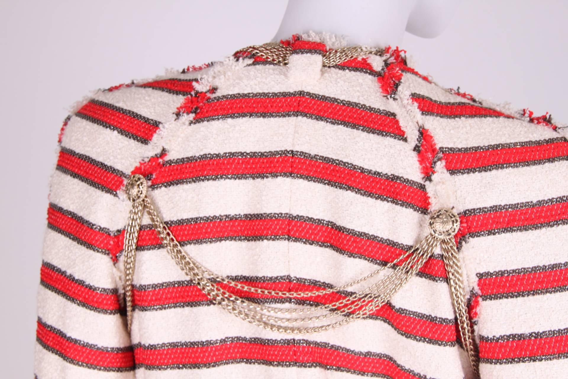 Wowww! This piece is rare and very special!

A Chanel jacket from the Stars & Stripes spring collection of 2008 covered with silver-tone chains in different sizes. At the end of each chain a metal CC logo is attached.

Striped in off-white, red and