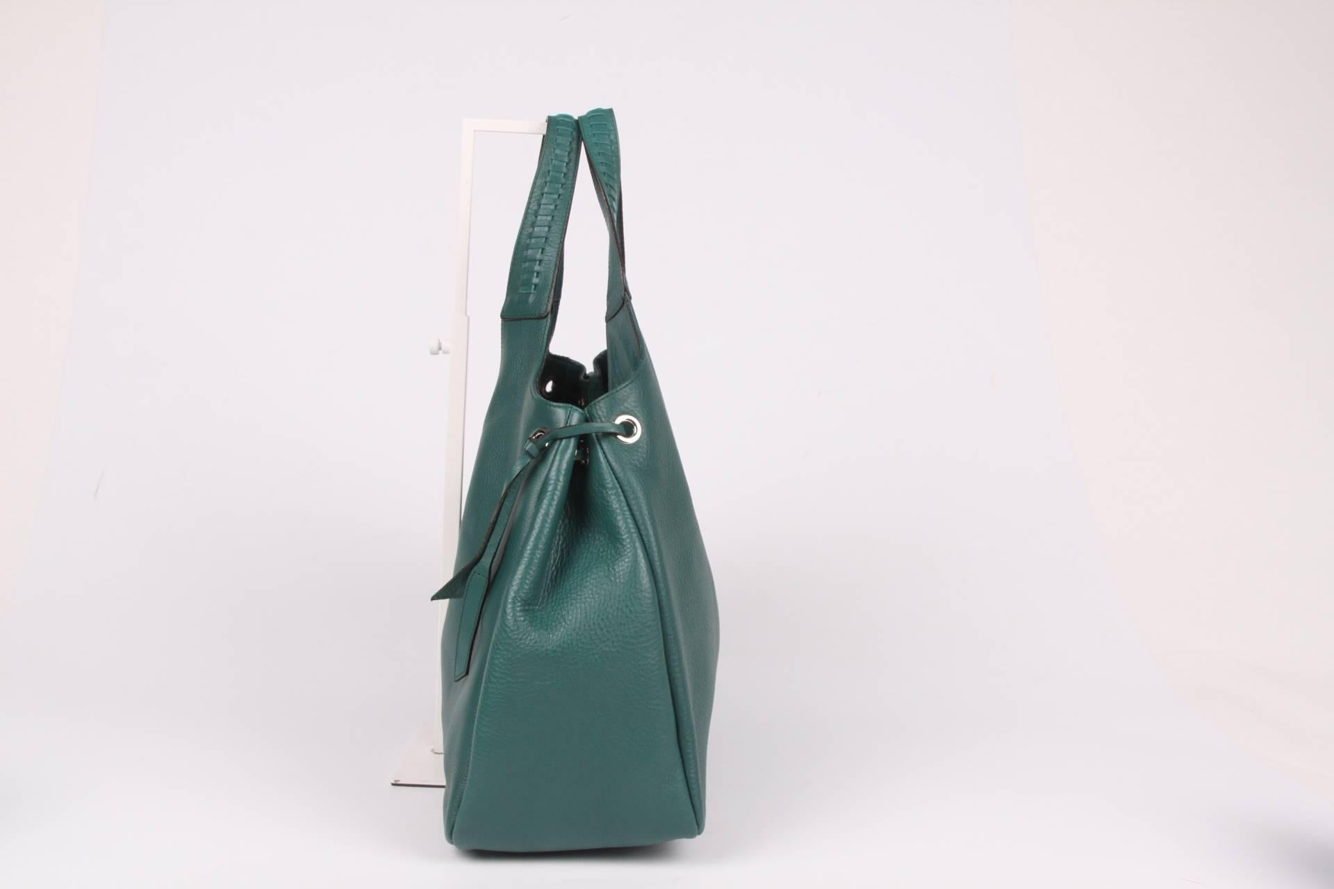 Oh la la, such a beauty! And brand new... A large calfskin leather shoulder bag by Salvatore Ferragamo in emerald green.

The leather of this bag is very supple, braided handles on top and straps on both sides. Very minimalistic silver-tone