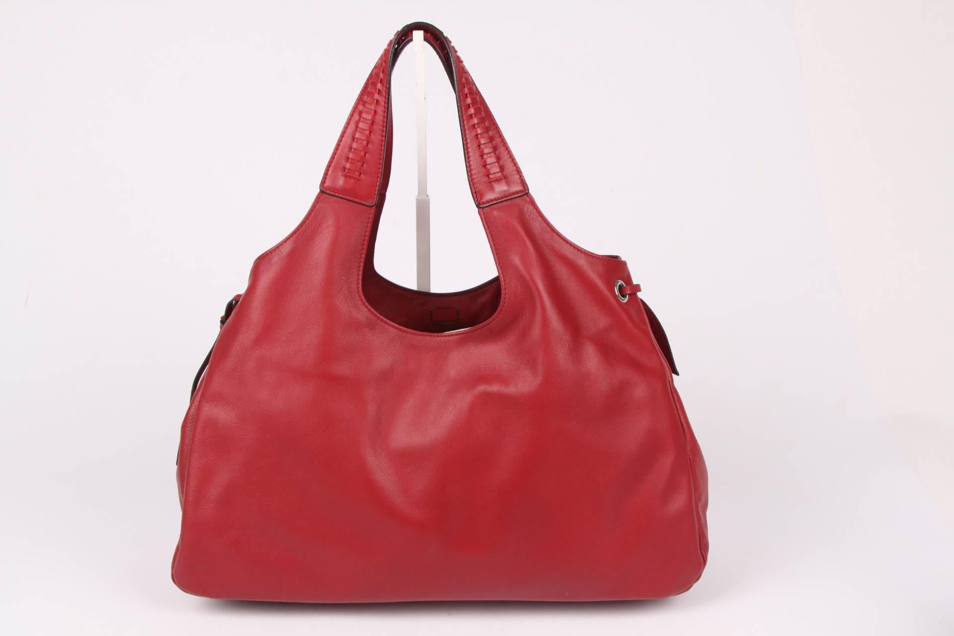 Oh la la, such a beauty! And brand new... A large calfskin leather shoulder bag by Salvatore Ferragamo in a warm shade of red.

The leather of this bag is very supple, braided handles on top and straps on both sides. Very minimalistic silver-tone
