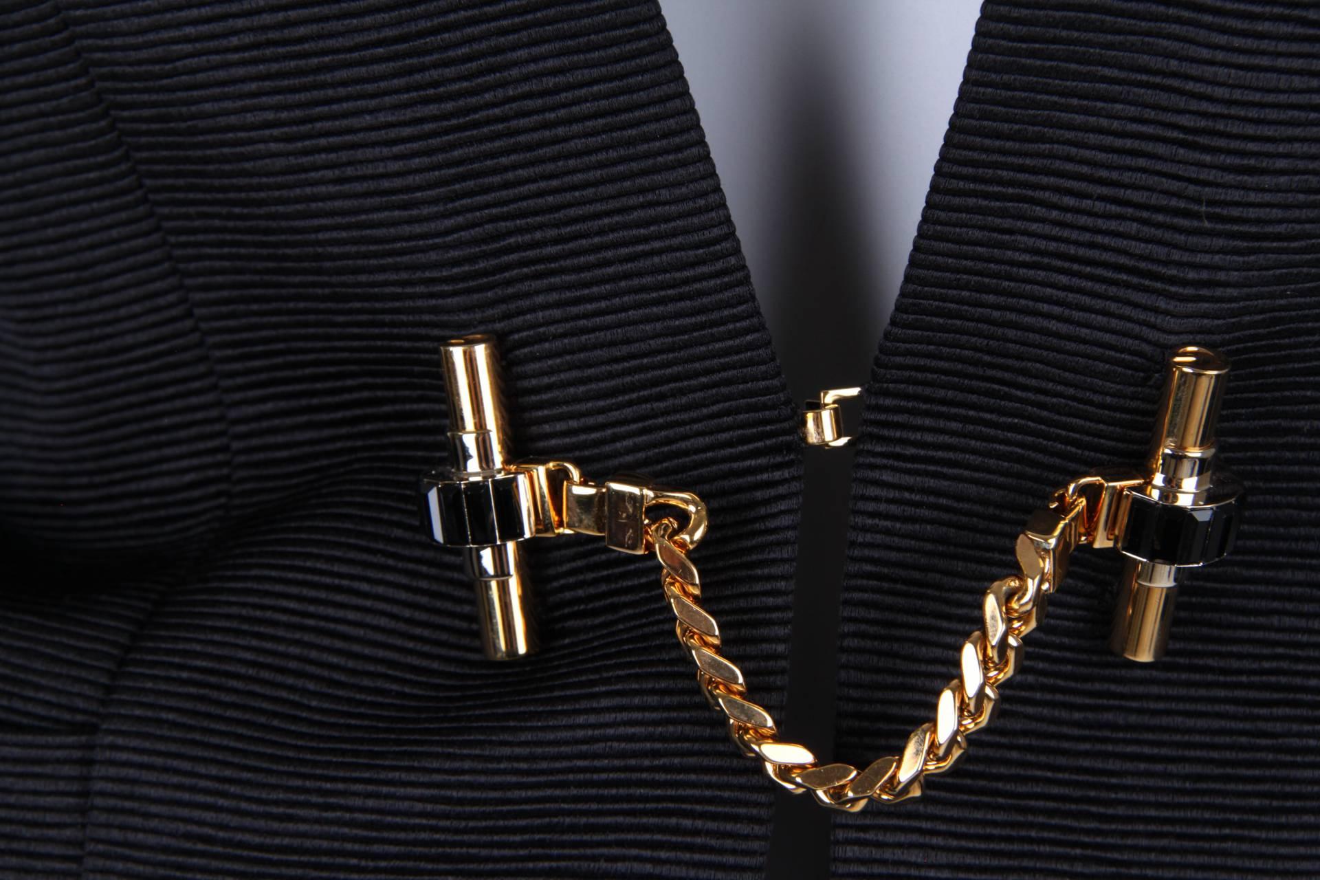 Magnificent Gucci jacket with golden detaling at the front.

Crafted in a softly shiny cotton and silk blend with small ridges. A narrow collar and attached lapels. Two welt pockets above the hips. Gold chain closure, on both sides a golden bar