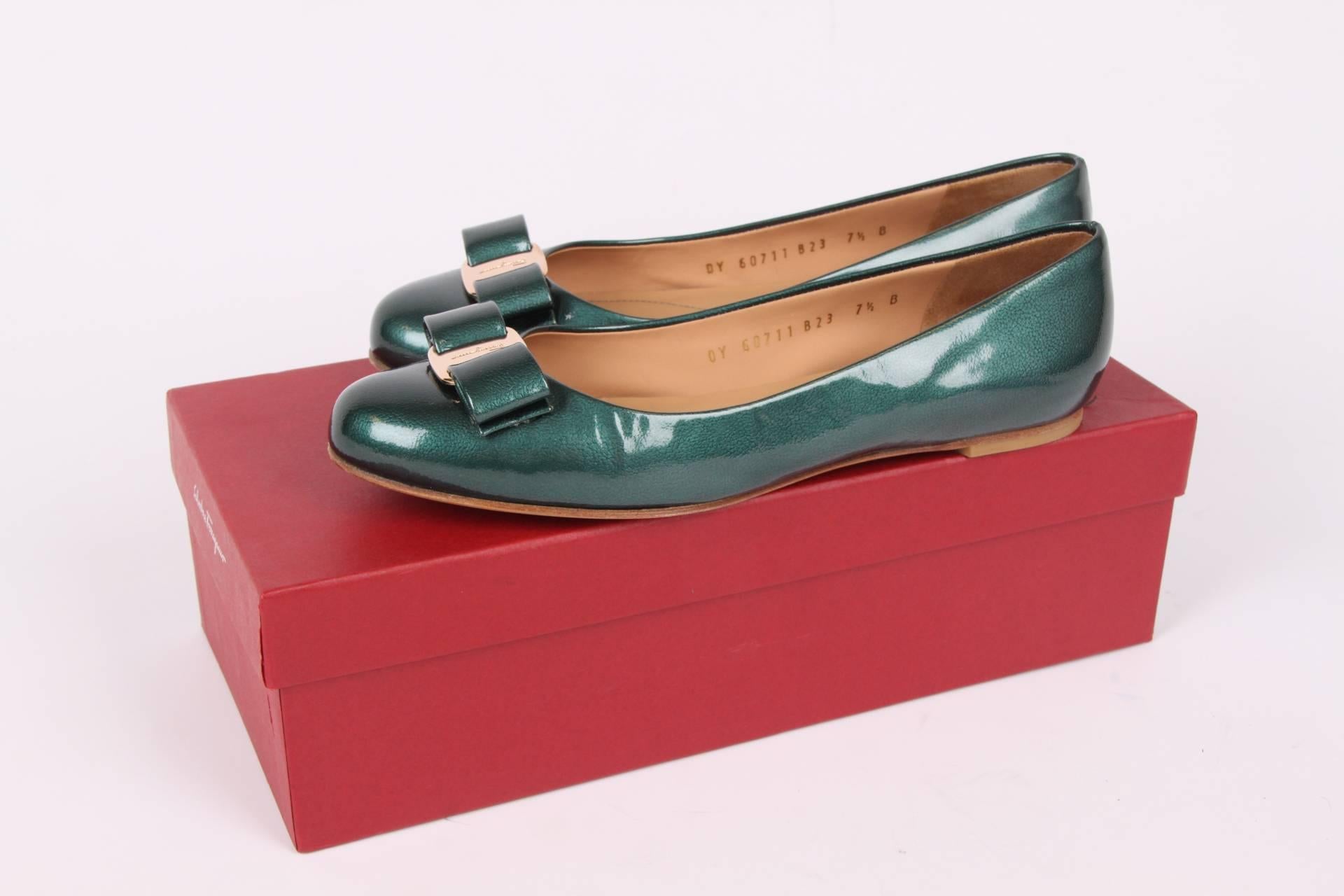 Chic ballerina flats by Salvatore Ferragamo crafted in green metallic patent leather.

A round toe with a bow and a shiny gold-tone metal plaque with embossing of a Ferragamo logo. Leather outsole and a low heel that measures a little under 1