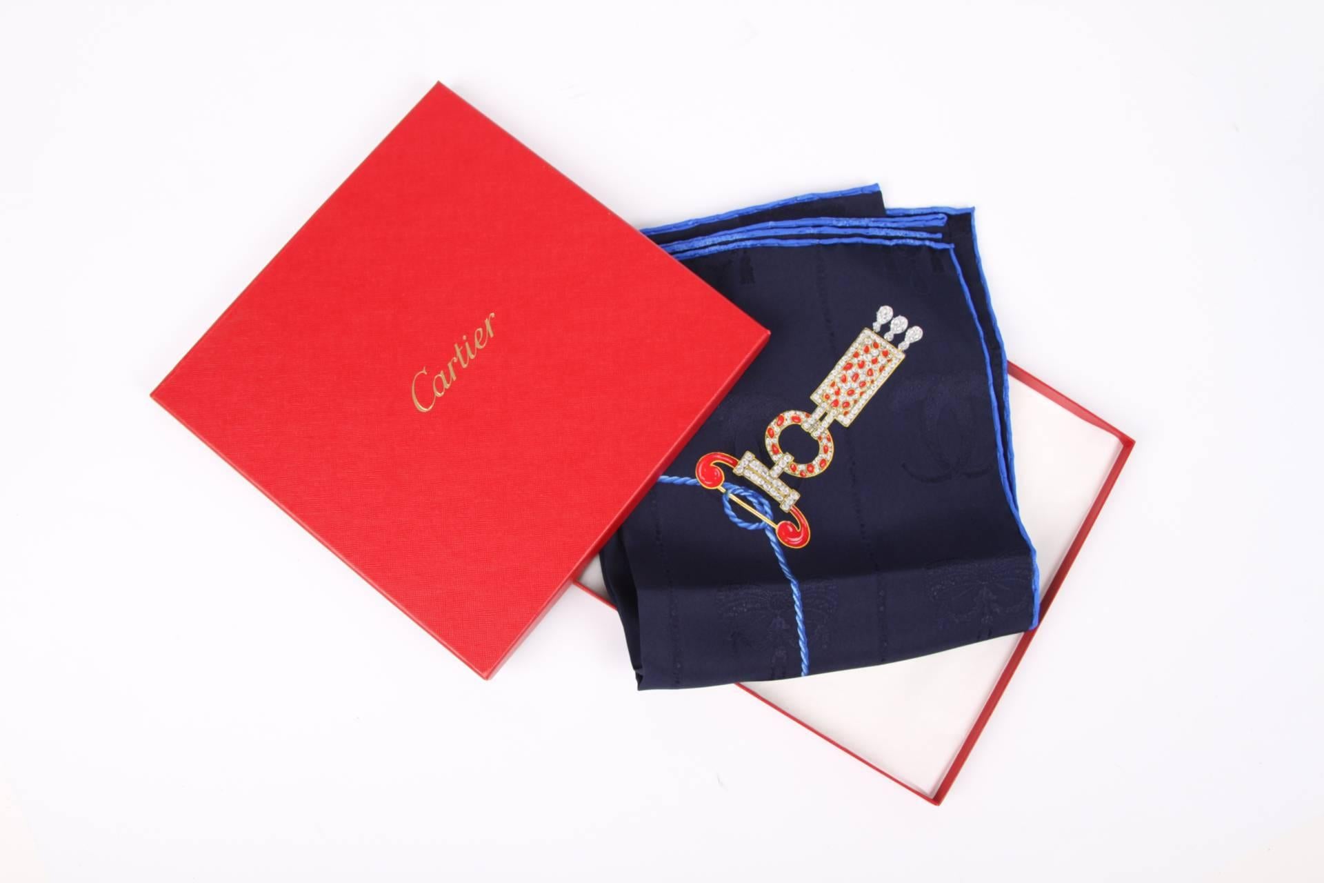 Diaphanous scarf by Cartier crafted in dark blue silk. Pretty!

The scarf is decorated with different pieces of jewelry in red, white, green and gold. On top of that you will find a woven pattern in the fabric. Very nice!

In perfect condition, new
