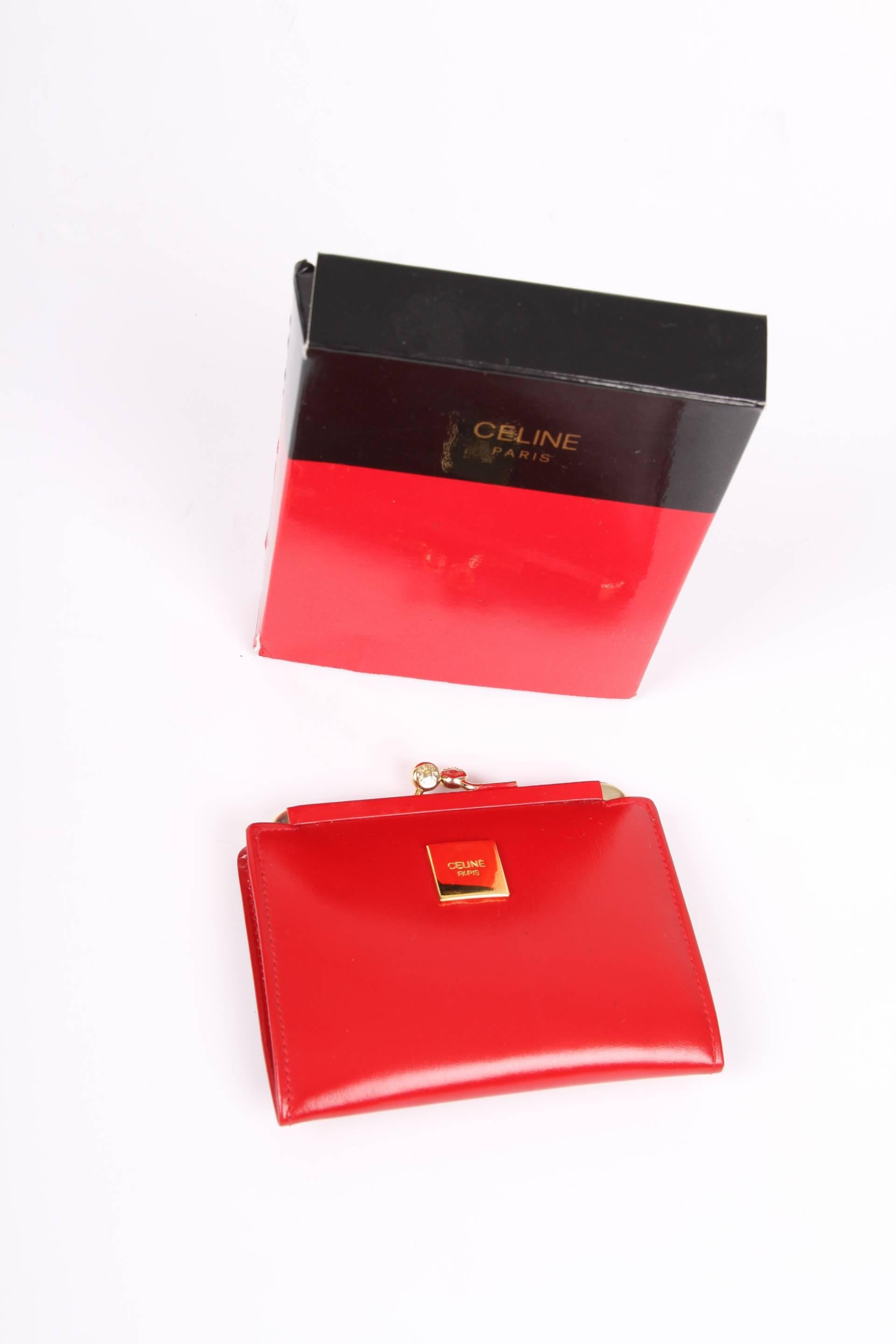 Red leather wallet by Céline Paris with a gold-tone closure on top.

At the front a small square gold-tone plaque with CELINE logo, fully lined with red leather, three compartments on the inside.

Small size, it does not fit a credit card. Of course