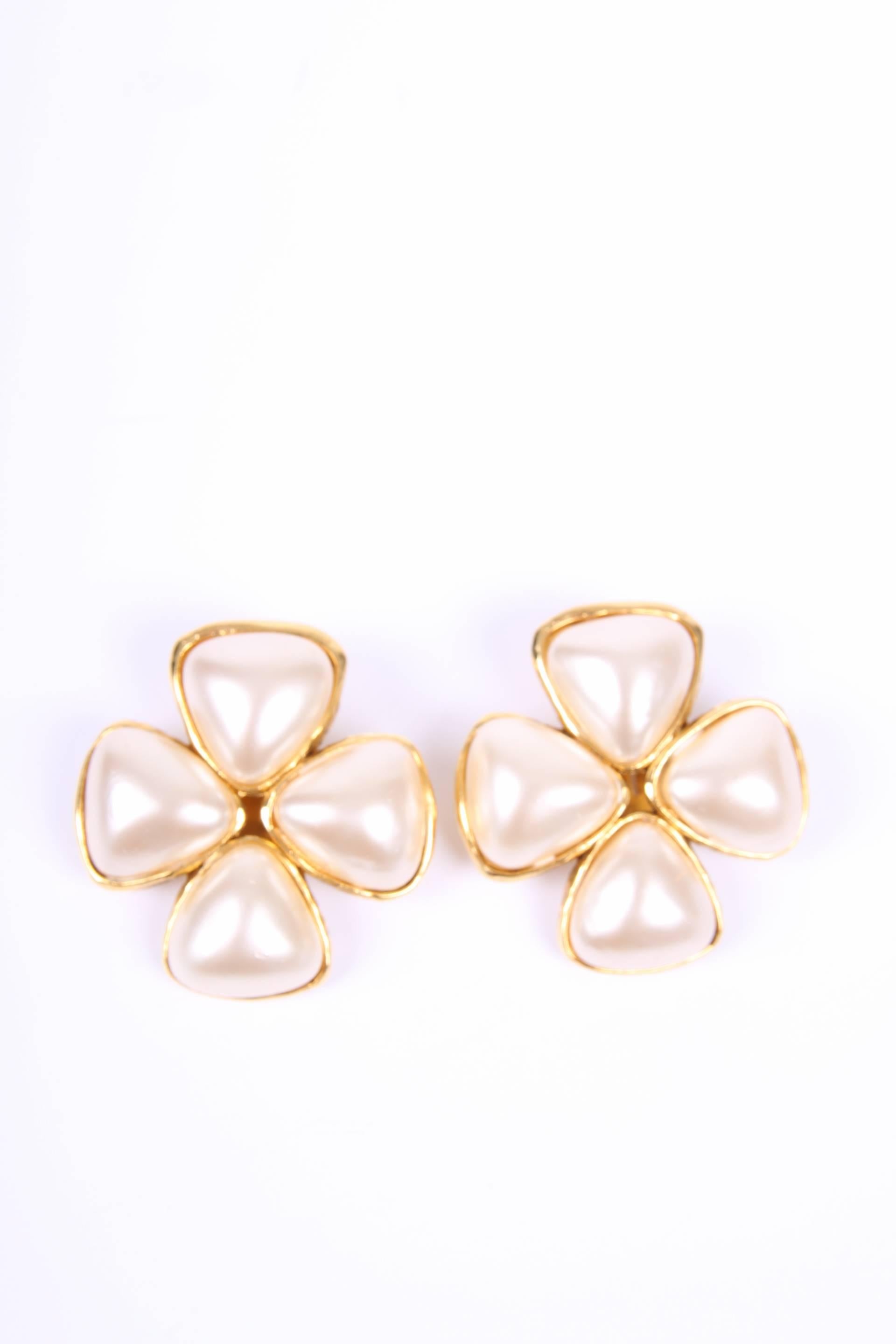 This is an authentic pair of Chanel clip earrings excuted in gold-tone metal with pearls.

The large faux pearls together have the shape of a four leaf clover. The back is gold plated and has a clip. On the plaque CHANEL 2 6 is engraved. We also