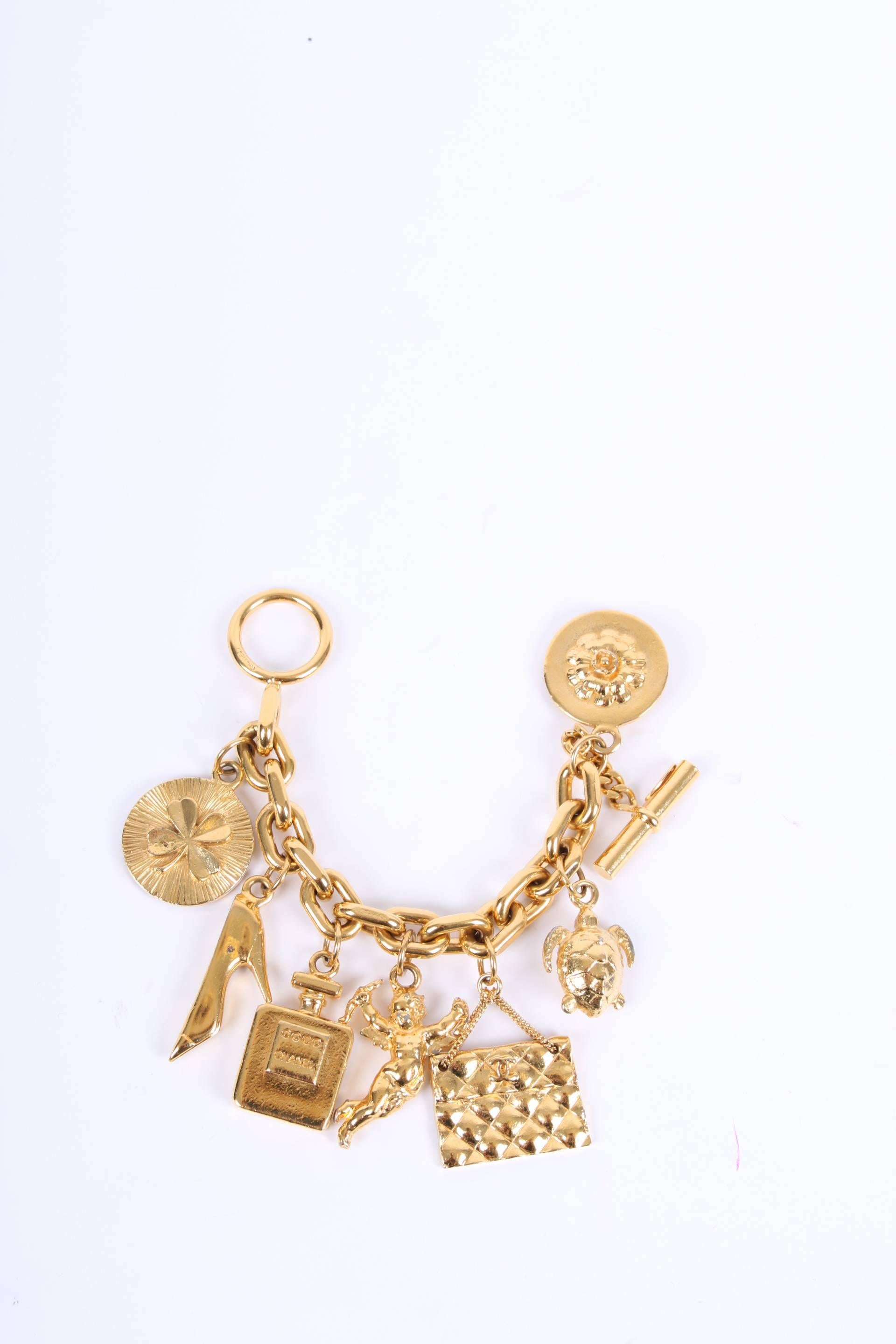 80's Vintage Chanel charm bracelet in a rather large size, a real statement piece!

This 24kt gold plated bracelet measures 20 centimeters and hold as much as 7 charms which represent the iconic fashion brand: a four-leaf clover, a stiletto, Coco
