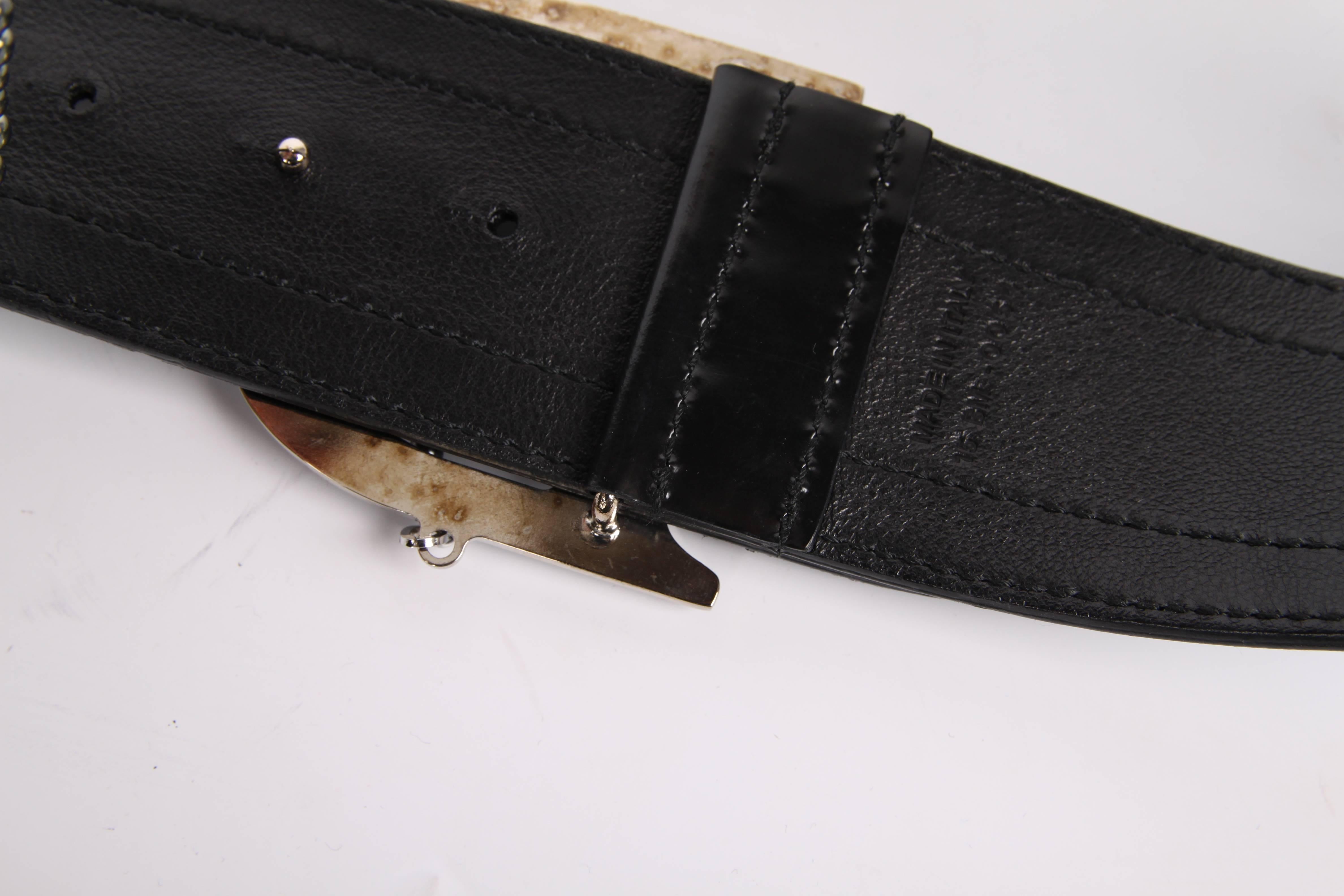 This one is super neat! A monogram belt by Christian Dior crafted of black leather with a big silver-tone reflecting D buckle.

Grey and white monogram canvas in the center, above and below a strip of black leather. A silver grey pearl string is