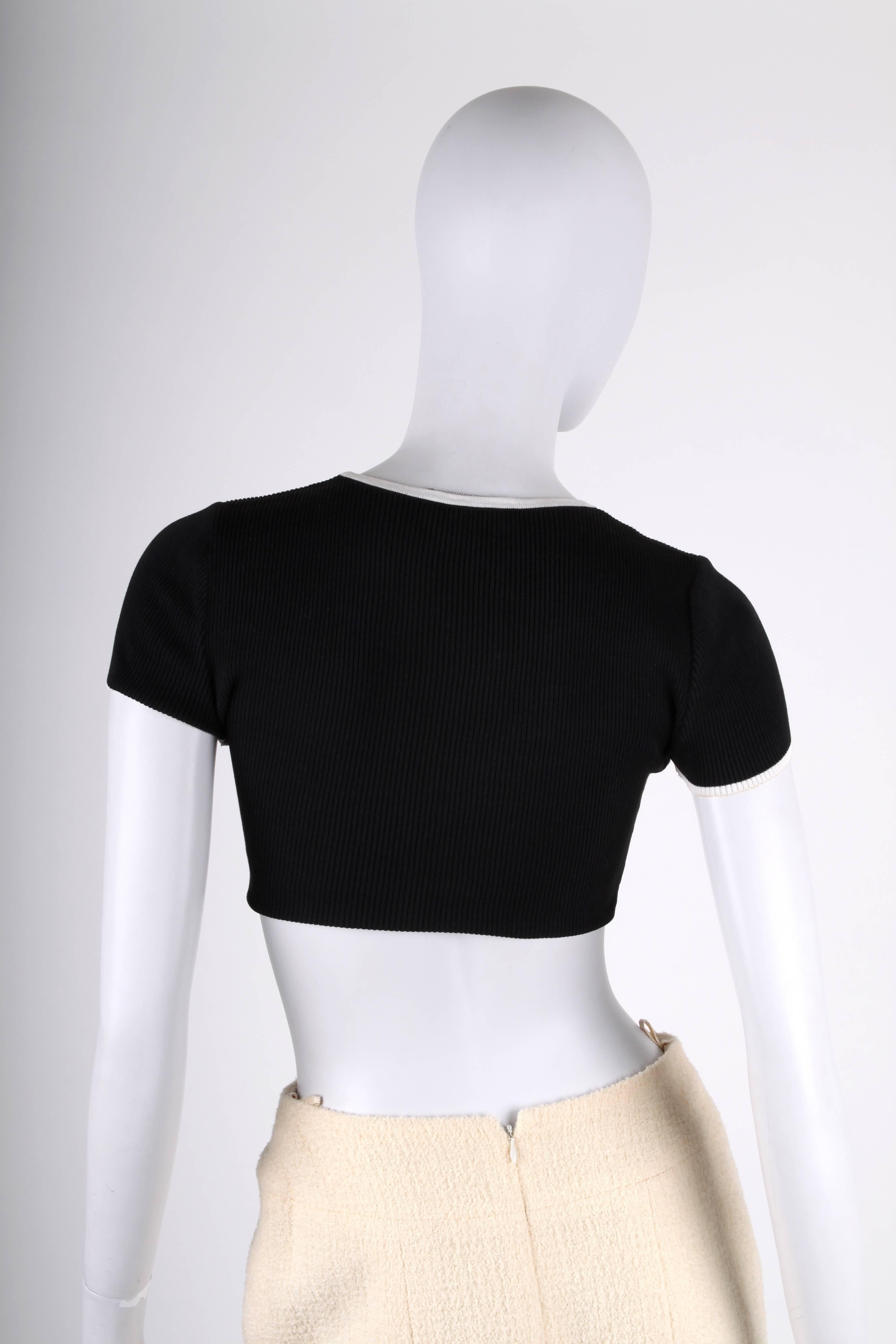 Cute little crop top by Chanel. Sweet!

Short sleeves with white piping, this piping can also be found at the round neckline and at the bottom. Right below the round neckline there is a white embroidered CC logo. Stretching material.

In fair