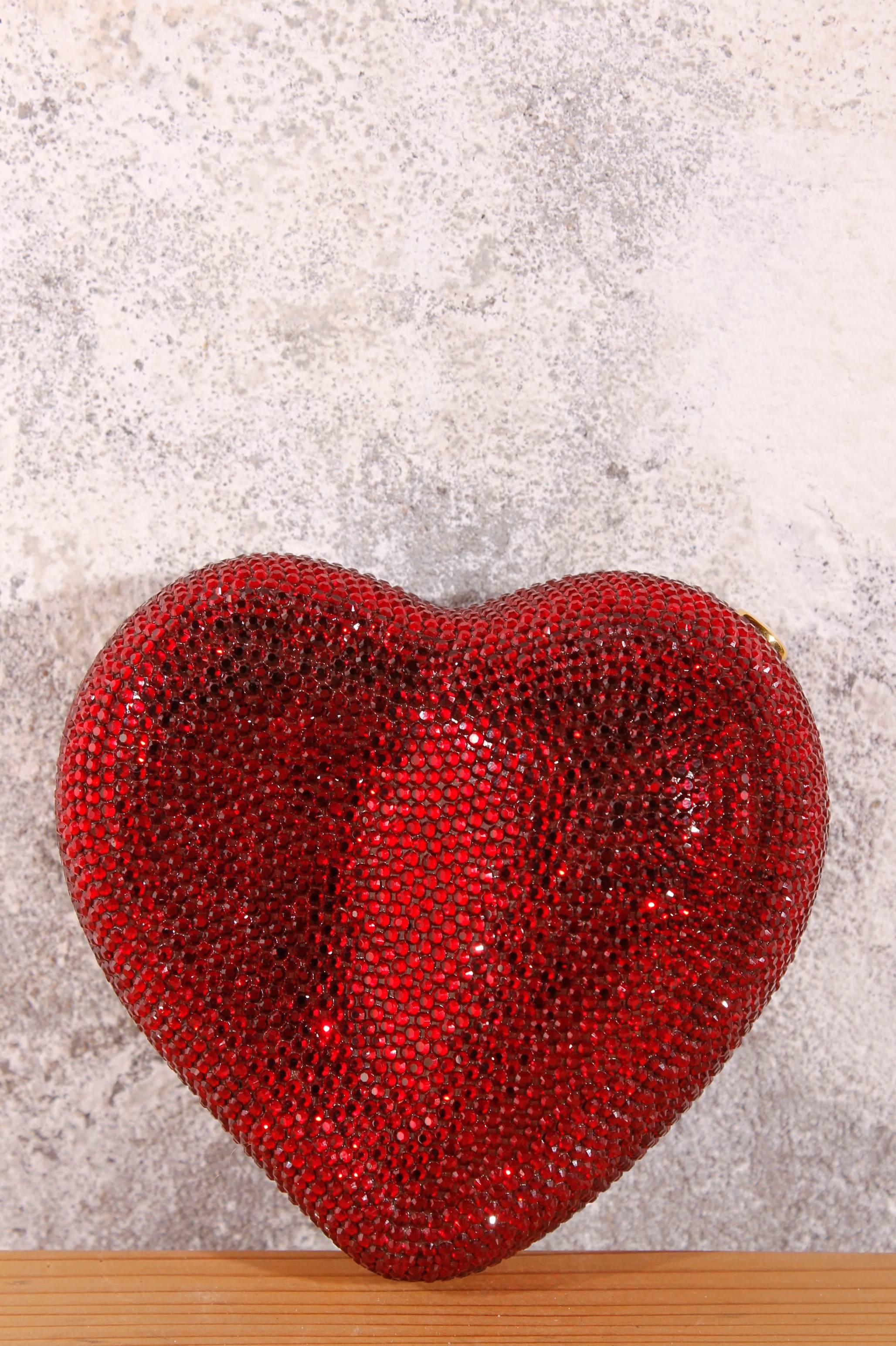 Sweet! Fantastic Judith Leiber New York clutch in a heart-shape, fully covered with red rhinestones. Officially this bag is called: 'Heart 'n Soul Sequin Bag'.

An one-in-a-million piece; a golden wrist-chain, a little top button closure 
and