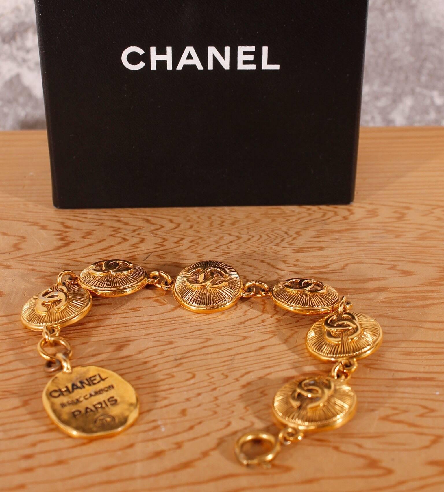 Straight from the eighties is this Chanel Rue Cambon Paris bracelet! Nice!

A gold plated bracelet of six golden medaillons with a large CC-logo in the middle. Around the logo little stripes like sunbeams. At the back of the medaillion a