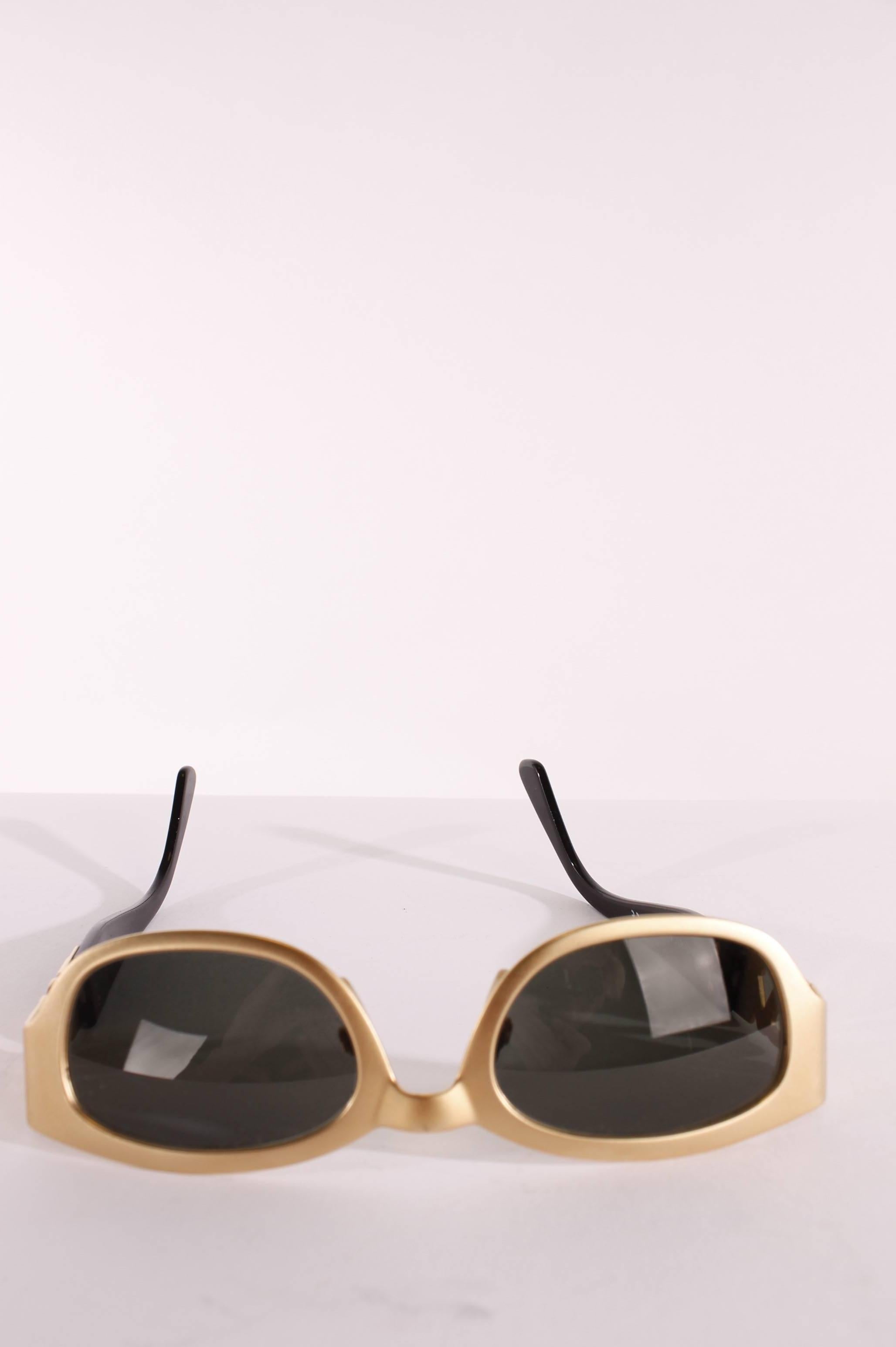 A vintage pair of sunglasses made by Luxottica for Yves Saint Laurent.

The frame is made of golden very light weight metal and square shaped, lenses are grey. Glasses are like new, unfortunately the box is slightly damaged. 
Beautiful