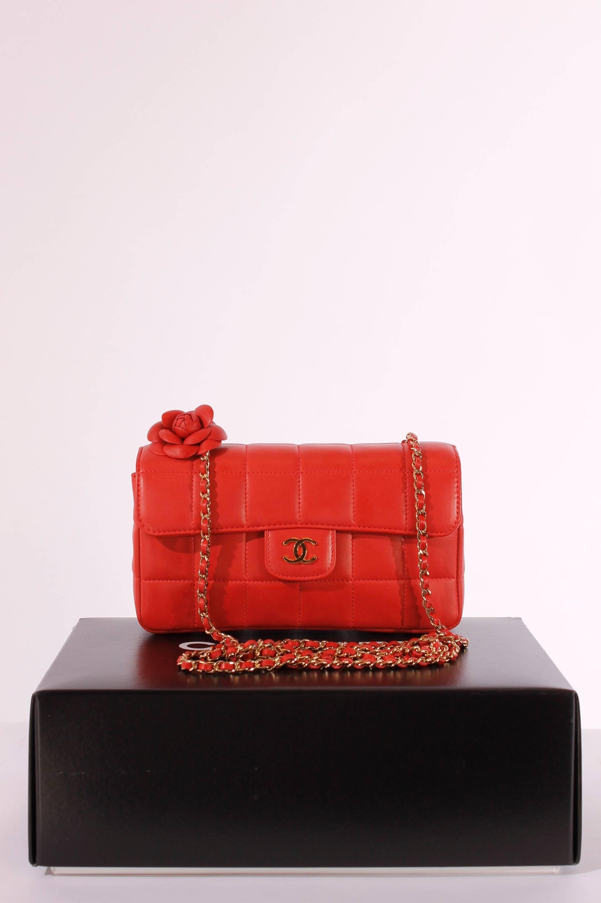 Soooo cute! Coral coloured Chanel bag with a thin long golden chain, perfect to wear cross-body.

This beauty is officially called the Chanel Square Quilt Camellia Mini Flap Bag, the leather camellia flower a the bottom of the chain is probably