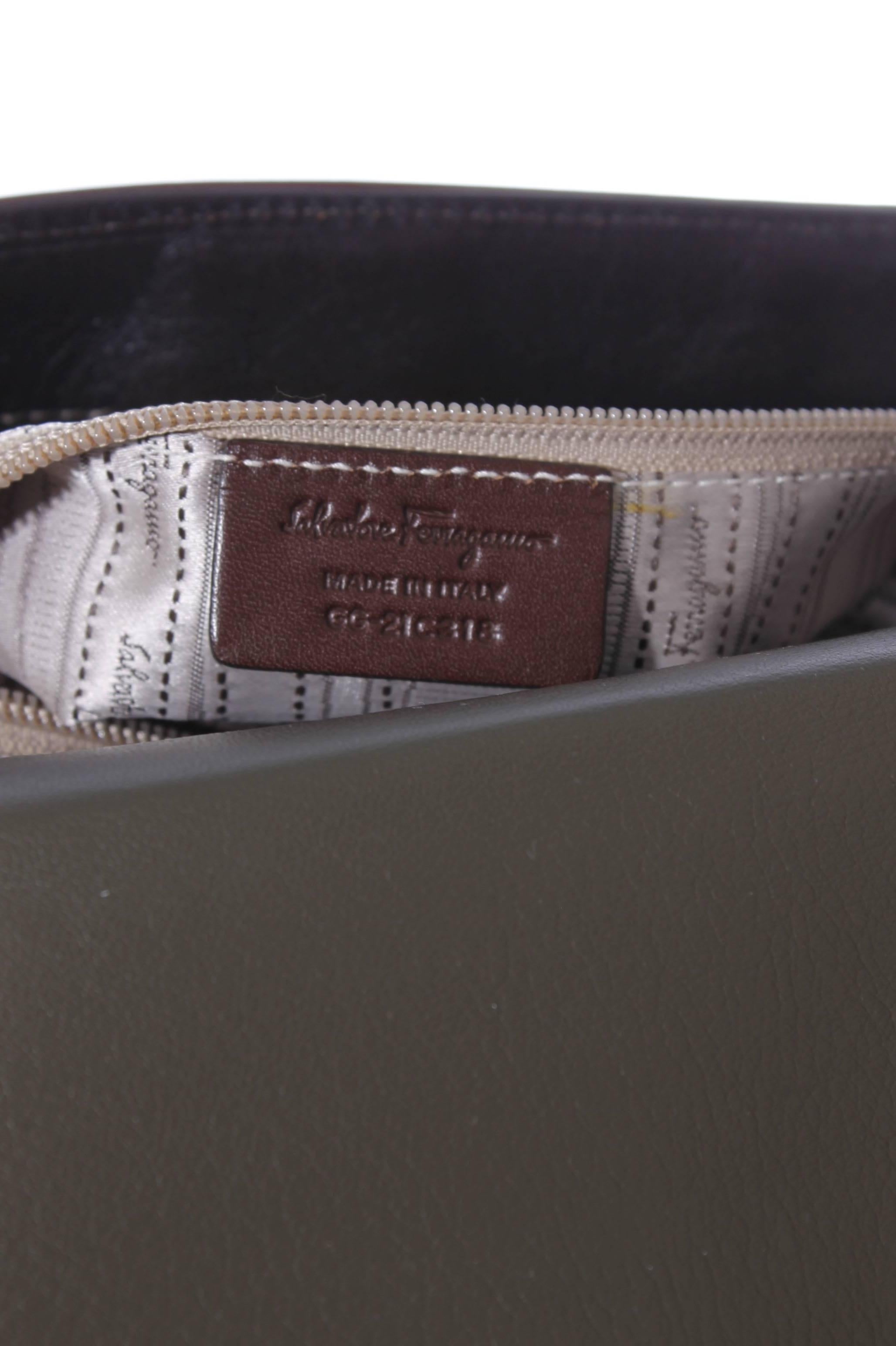 This Salvatore Ferragamo bag is made of leather in brown and army green. The green part is woven, the brown part is smooth. It's the Sofia Large Tote Bag, a true beauty!

Shiny golden hardware, a long zipper on the back. Another zipper underneath