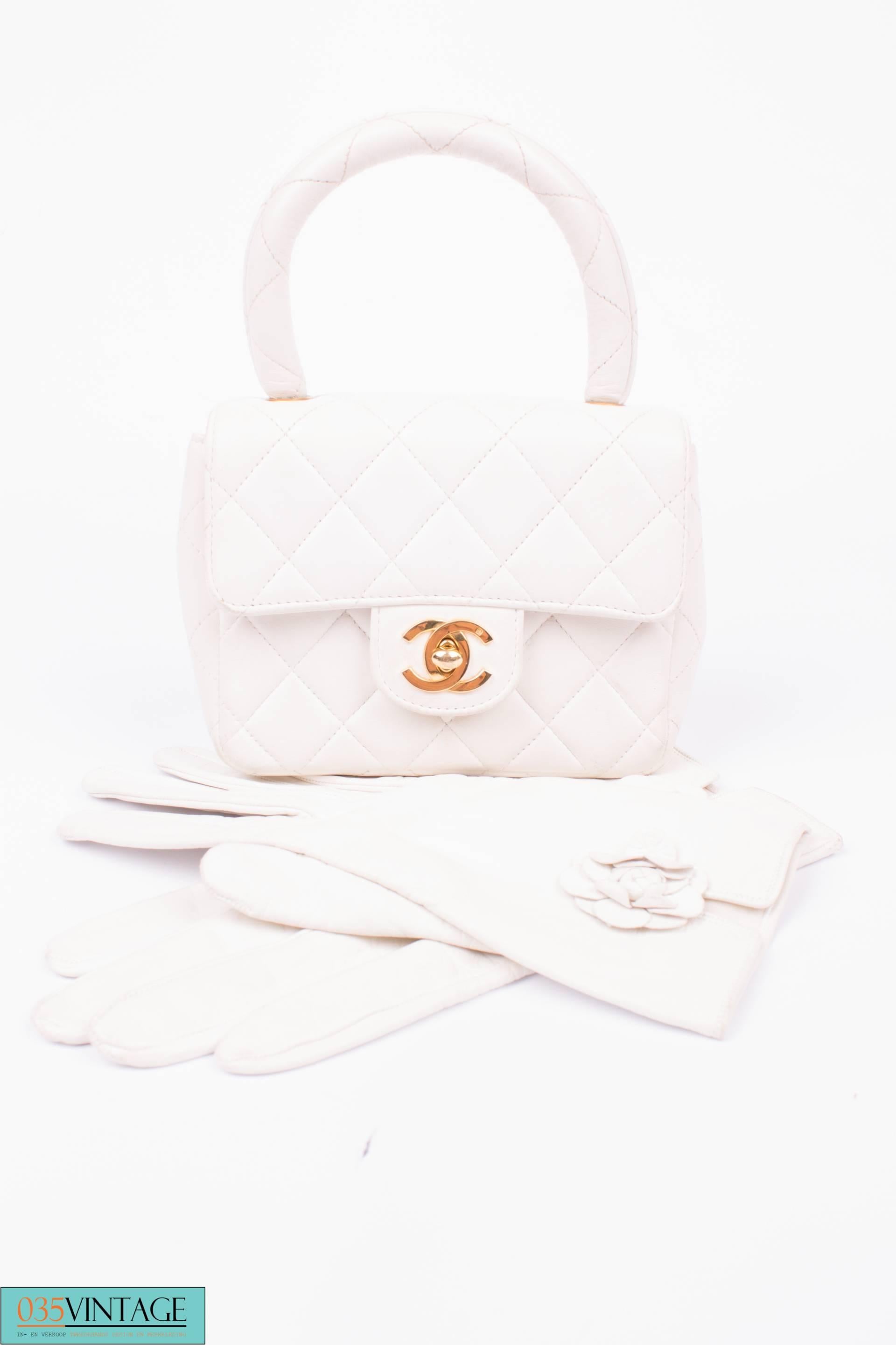 A vintage mini bag by Chanel, isn't she adorable?! It is the Chanel Mini Kelly Flap Bag in off-white lambskin leather.

This cutie is fully quilted and has a rolled top handle and a goldtone interlocking CC turn-lock closure on the flap. A so called