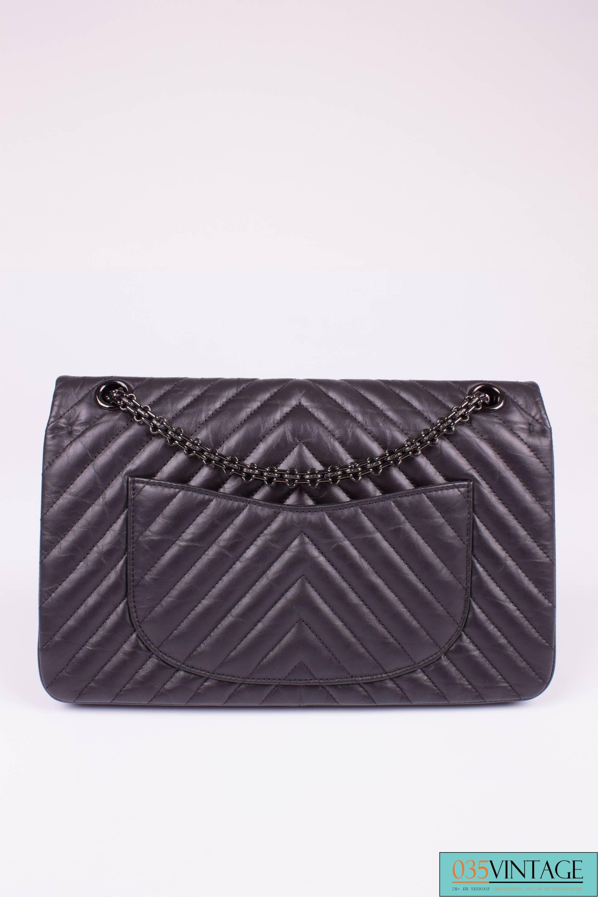 A very rare beauty, we do not see this one very often! It is the Chanel 2.55 Reissue Chevron Quilted 224 Flap Bag in the color So Black.

Everything on this bag is black; the exterior leather, the lock, the chain and the zipper. Only the lining is