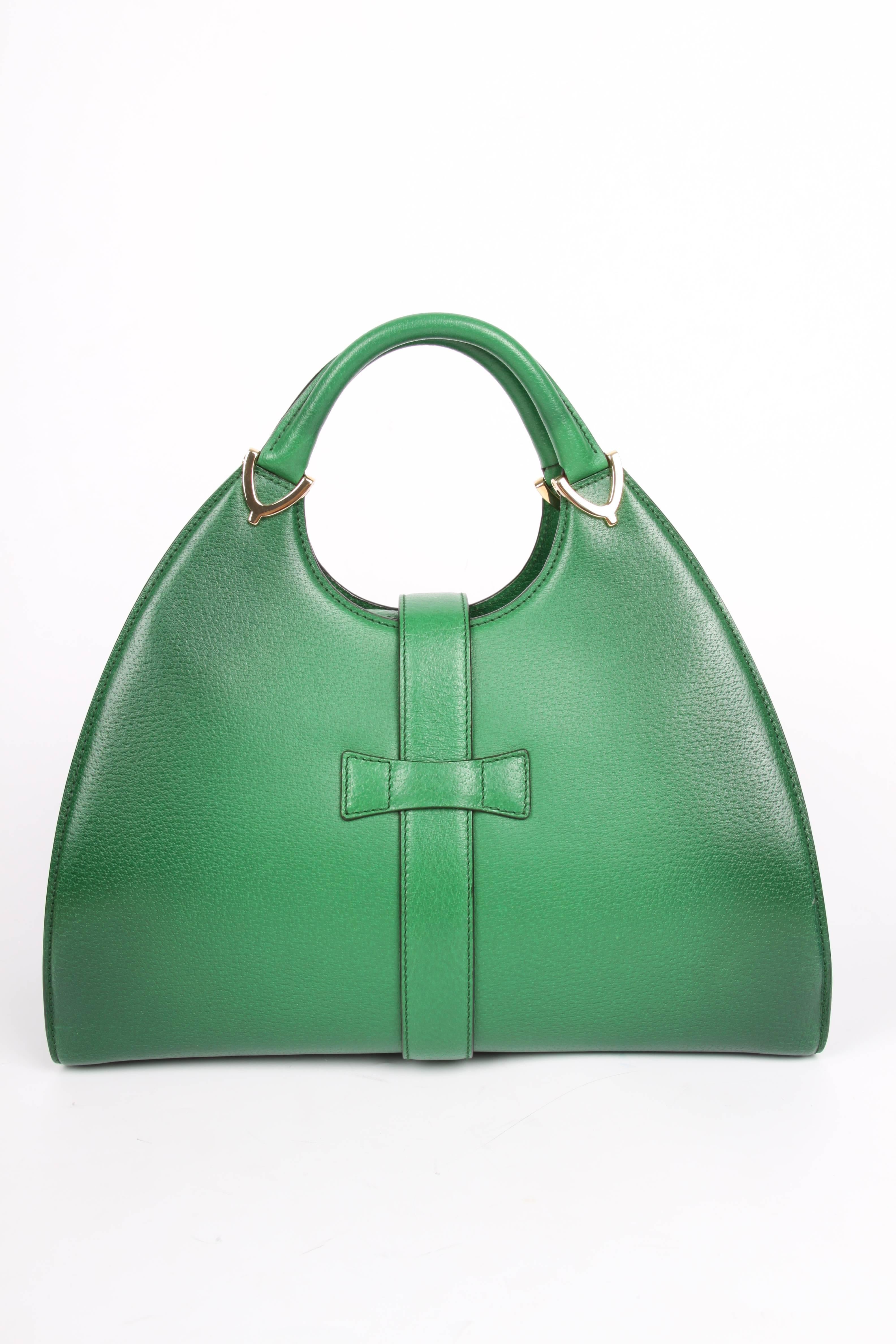 Oh, what a beauty! Green pig skin leather bag by Gucci; this is the Stirrip Top Handle Bag.

A popular bag in a rather large size, front closure with a strap and a push button and gold-tone hardware.

Inside lining in black leather. Two flat