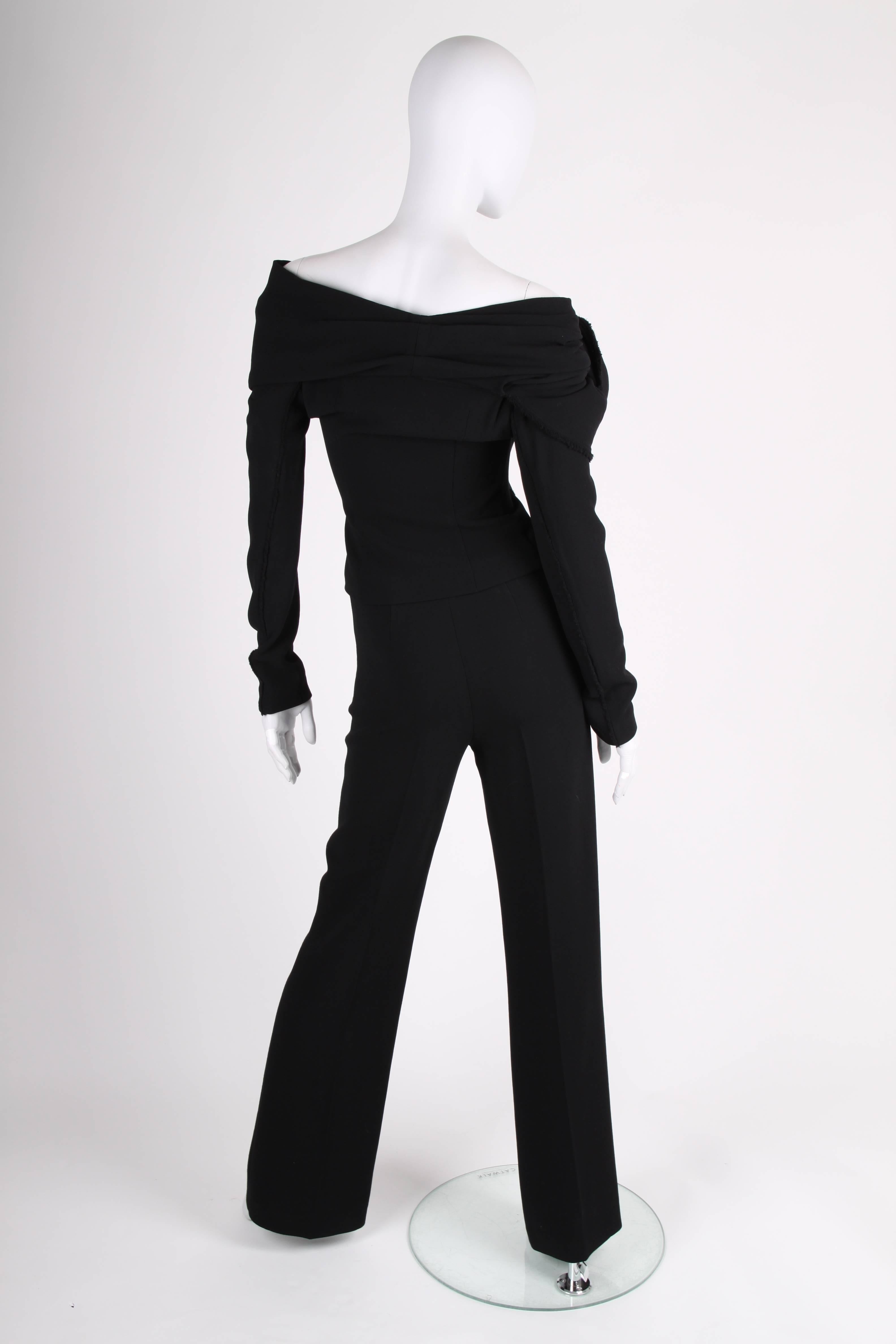 Donna Karan made this wonderful black suit! A wrap top and flared trousers.

The of-shoulder wrap top has hook closure on both sides, long sleeves, a large collar and is embellished with a XL flower on the right side. No lining. 

The pair of
