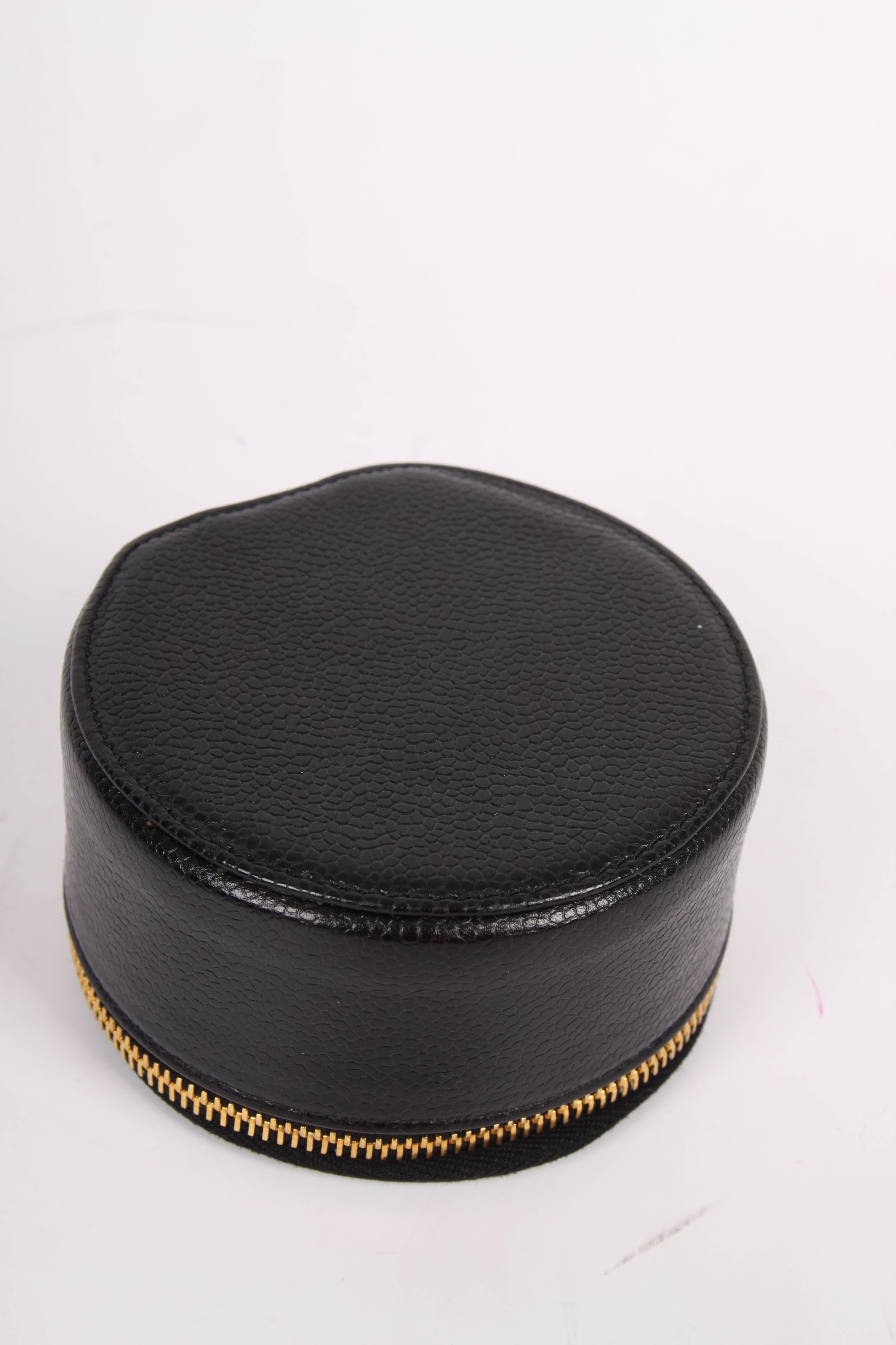 A wonderful vintage jewelry box by Chanel crafted of black caviar leather.

On top a large embroidered CC logo, gold-tone zip closure with a CC dangle. Lining on the inside in black velvet; a lit and a velvet strap to create different compartments
