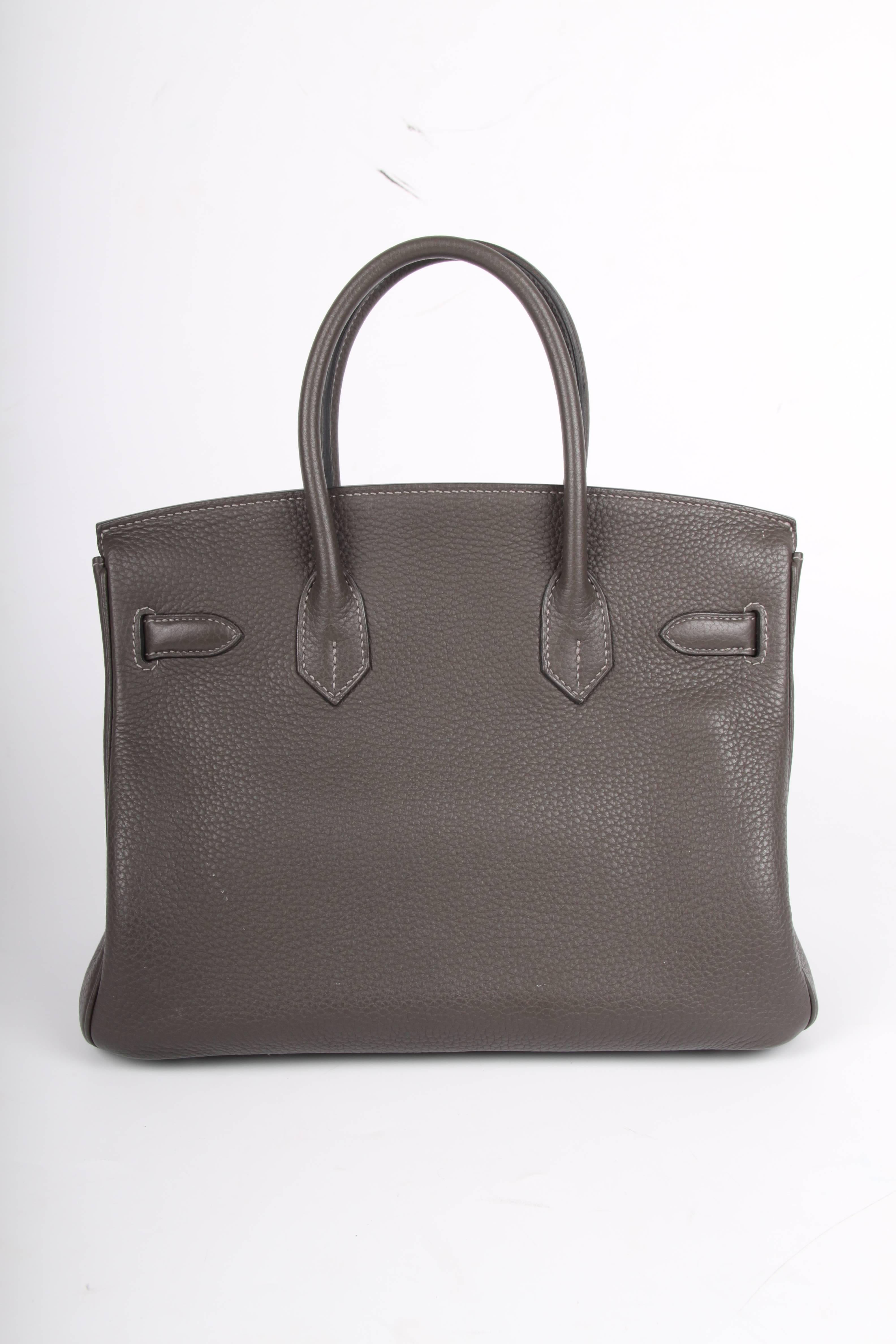 This bag is absolutely gorgeous; a Hermès Birkin Bag 30 with silver-tone hardware in dark grey Clemence leather, this color is called Graphite.

Front toggle closure, clochette with lock and two keys, and double rolled handles. The Clemence leather