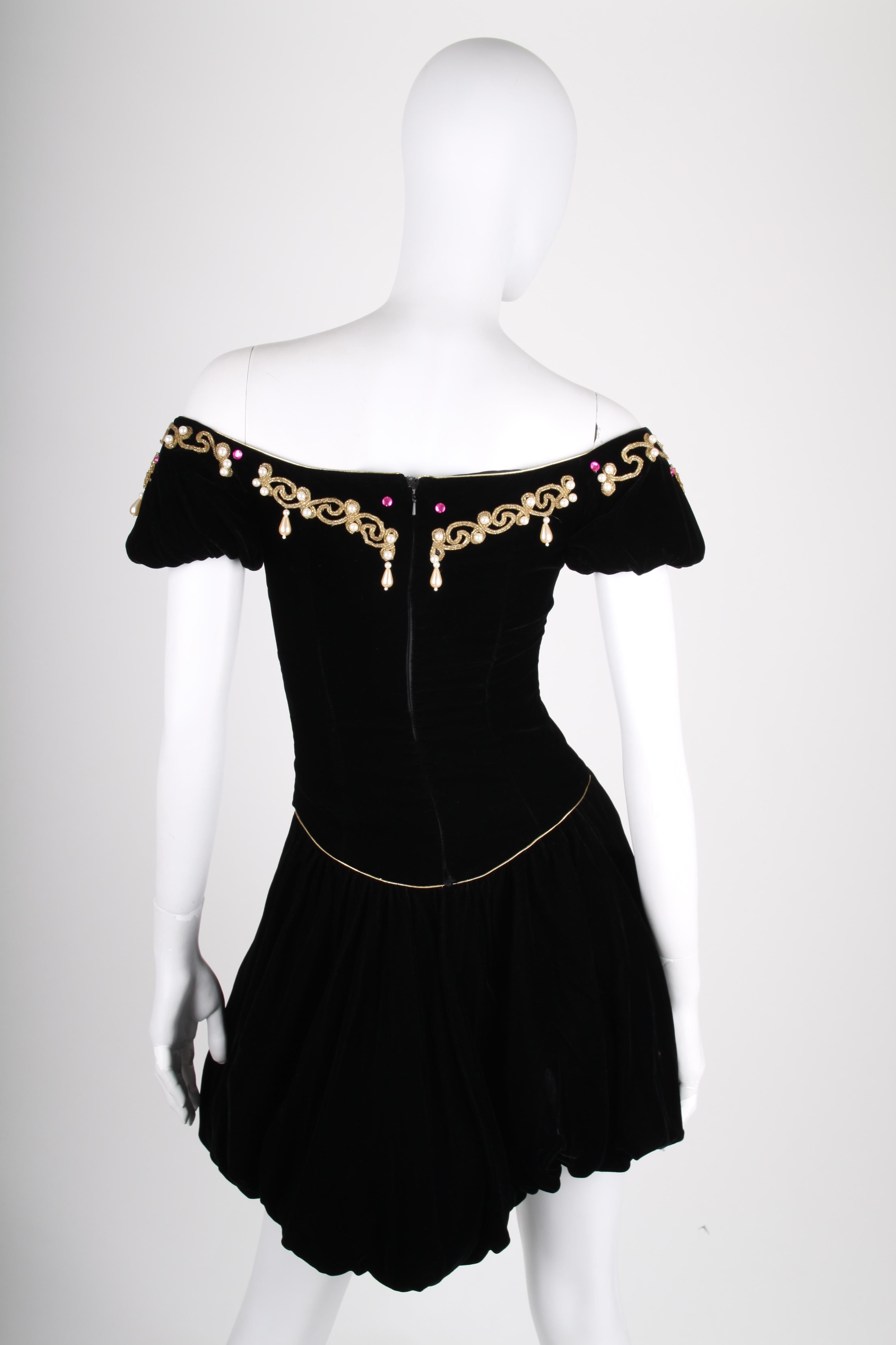 Adorable! Vintage dress by David Fielden London in black velvet.

An off-shoulder neckline embellished with gold-tone ornaments, pearls and shiny gemstones in pink and green. Back closure with a zipper, fully lined with black satin. The balloon