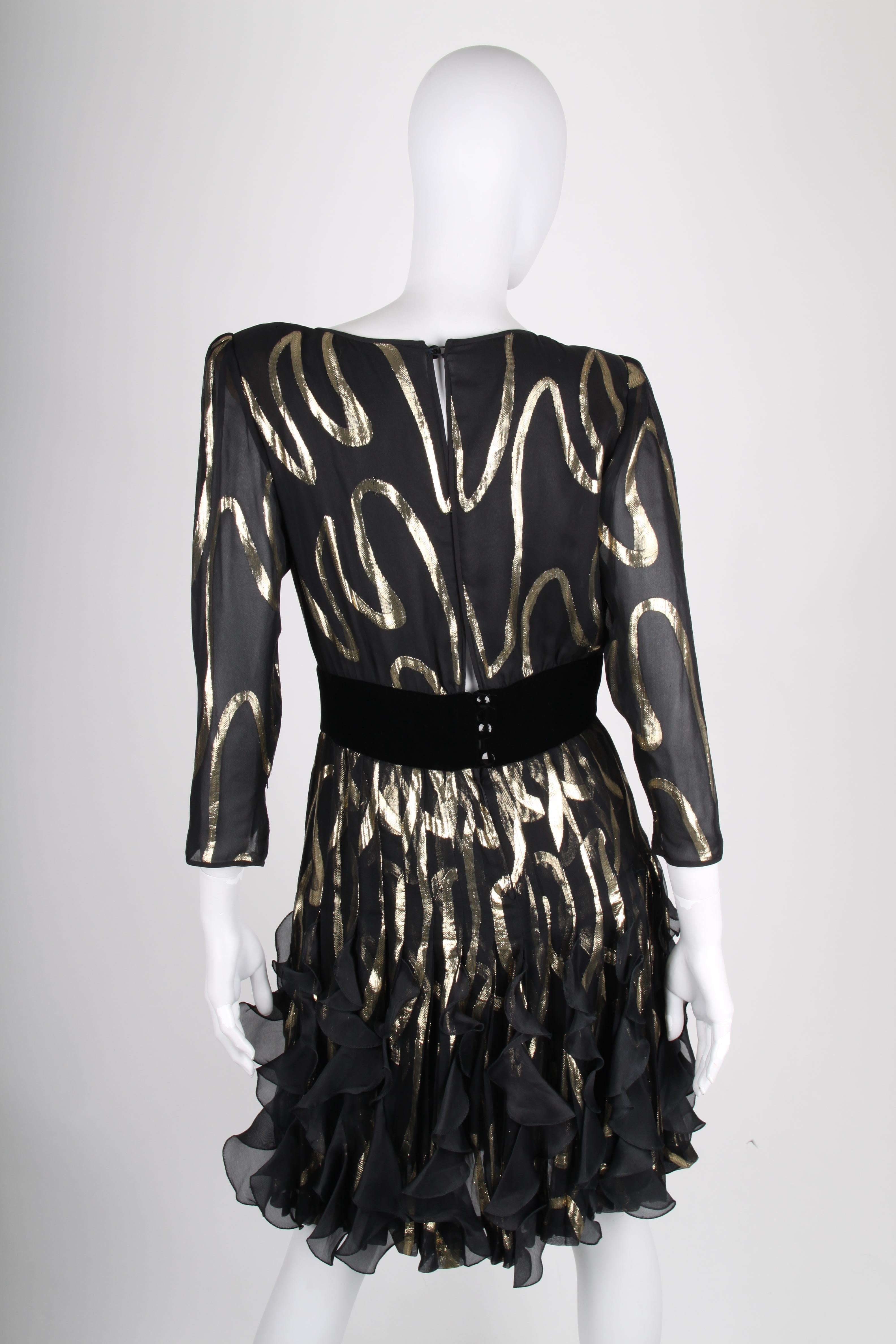 Woww! How festive! Vintage dress by Valentino in black silk with a gold-tone pattern.

Long sleeves and a round neckline, a velvet strap in the waist. Ruffles at the bottom of the skirt, fully lined, yet still a bit see-through. Back closure with a