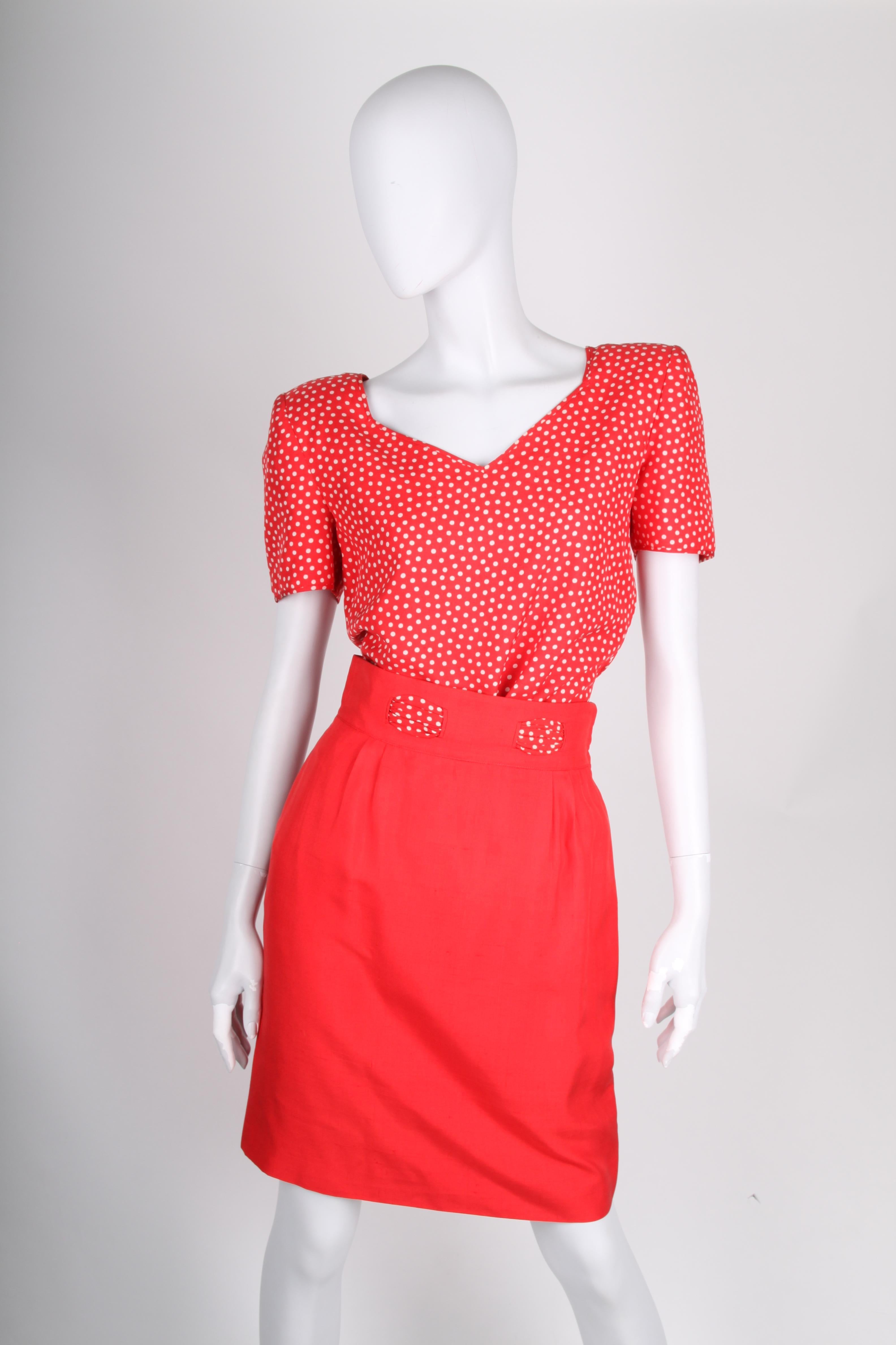Preppy 2-piece suit by Valentino NIGHT: a skirt and a top.

The dotted top has a V-neck, short sleeves and zip closure on the left side. Padding in the shoulders, no lining.

The short skirt is straight and the waistband is decorated with the dotted