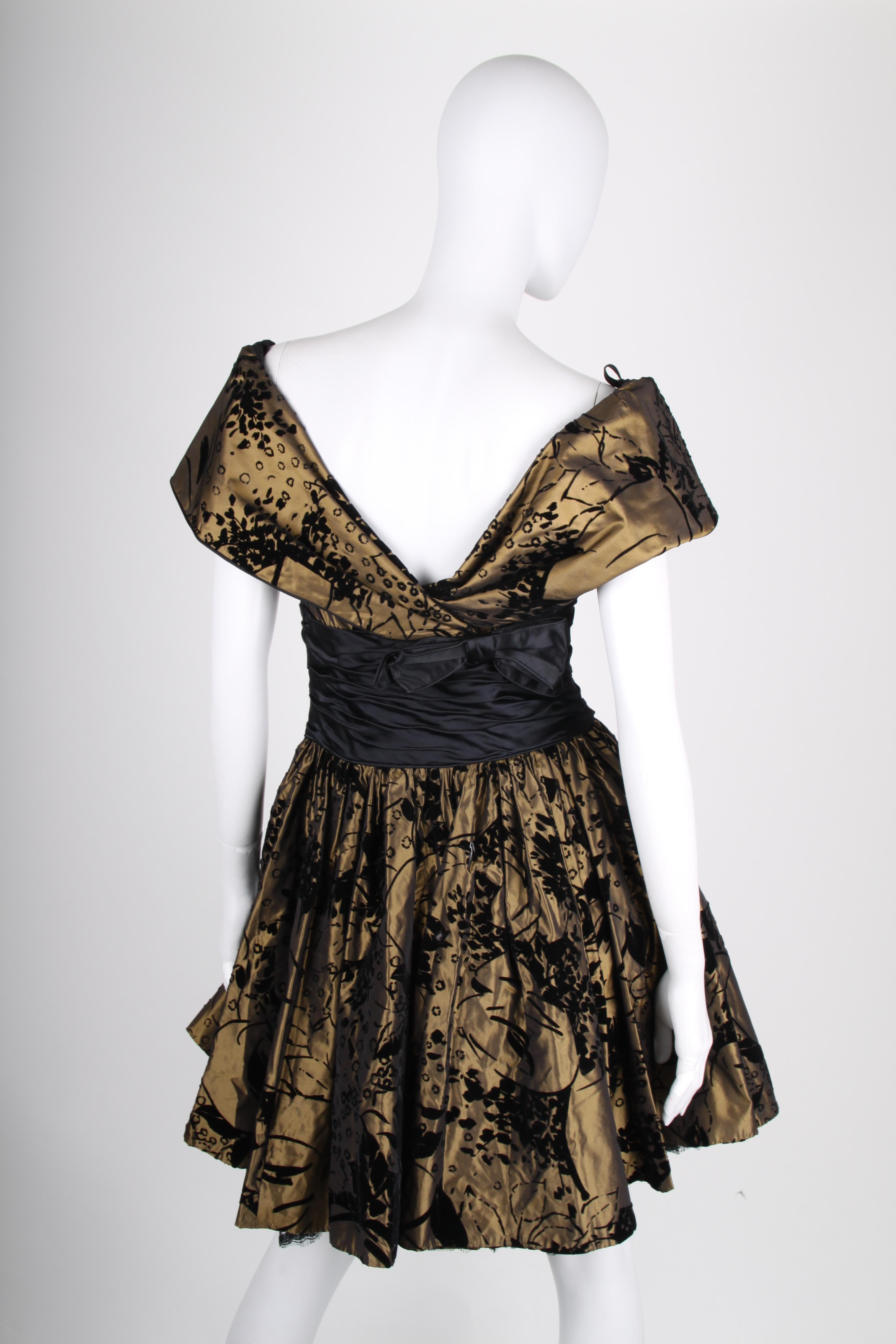 True vintage! Frank Govers made this beauty; a bronze coloured dress with a black velvet pattern.

An off-shoulder neckline, black satin in the waist and a bow on the back. Closure on the left side, upper side lined with black satin and the skirt