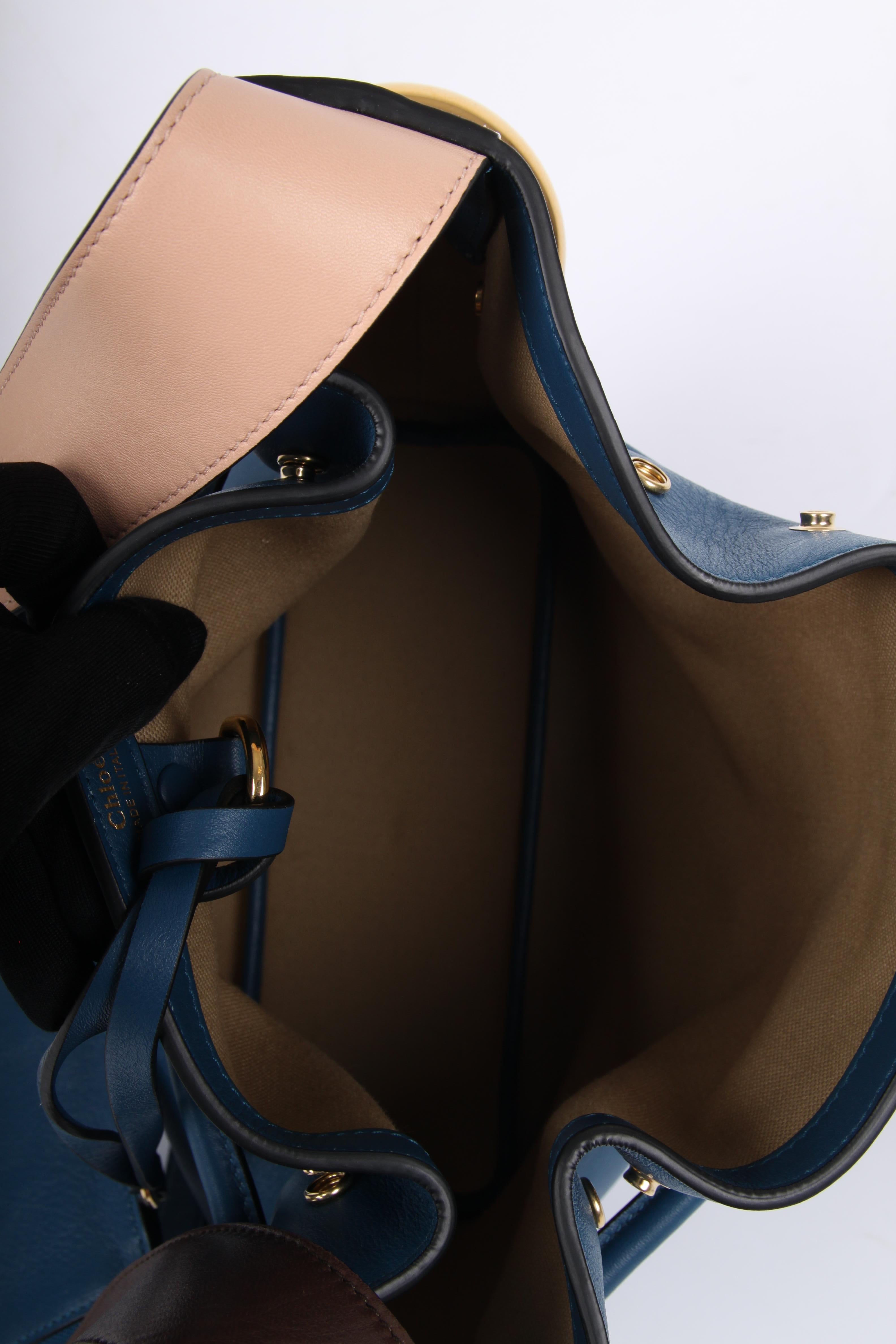This Chloe bucket bag is made from exquisite factory blue calfskin with gold-tone hardware. Details include a brown leather shoulder strap, looping drawstring, and fully lined interior with a detachable pouch.  

Type of Material: CalfskinColor: