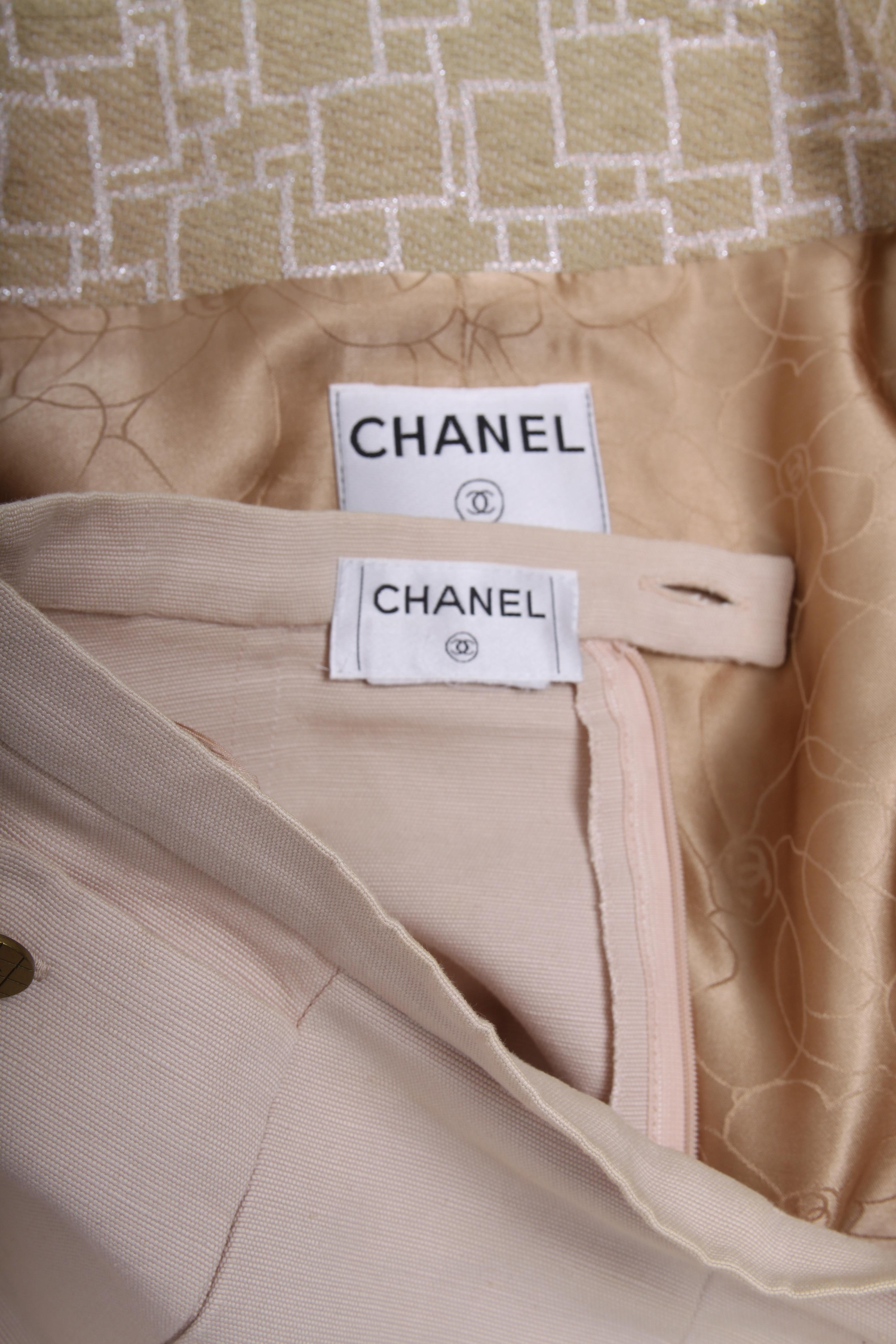 Not vintage yet... Two-piece beige Chanel suit from the Spring Collection of 2001.

The bouclé bodywarmer has front closure with a zipper and epaullettes on the shoulders with a matte silver button embellished with CC logo. The beige bouclé has a