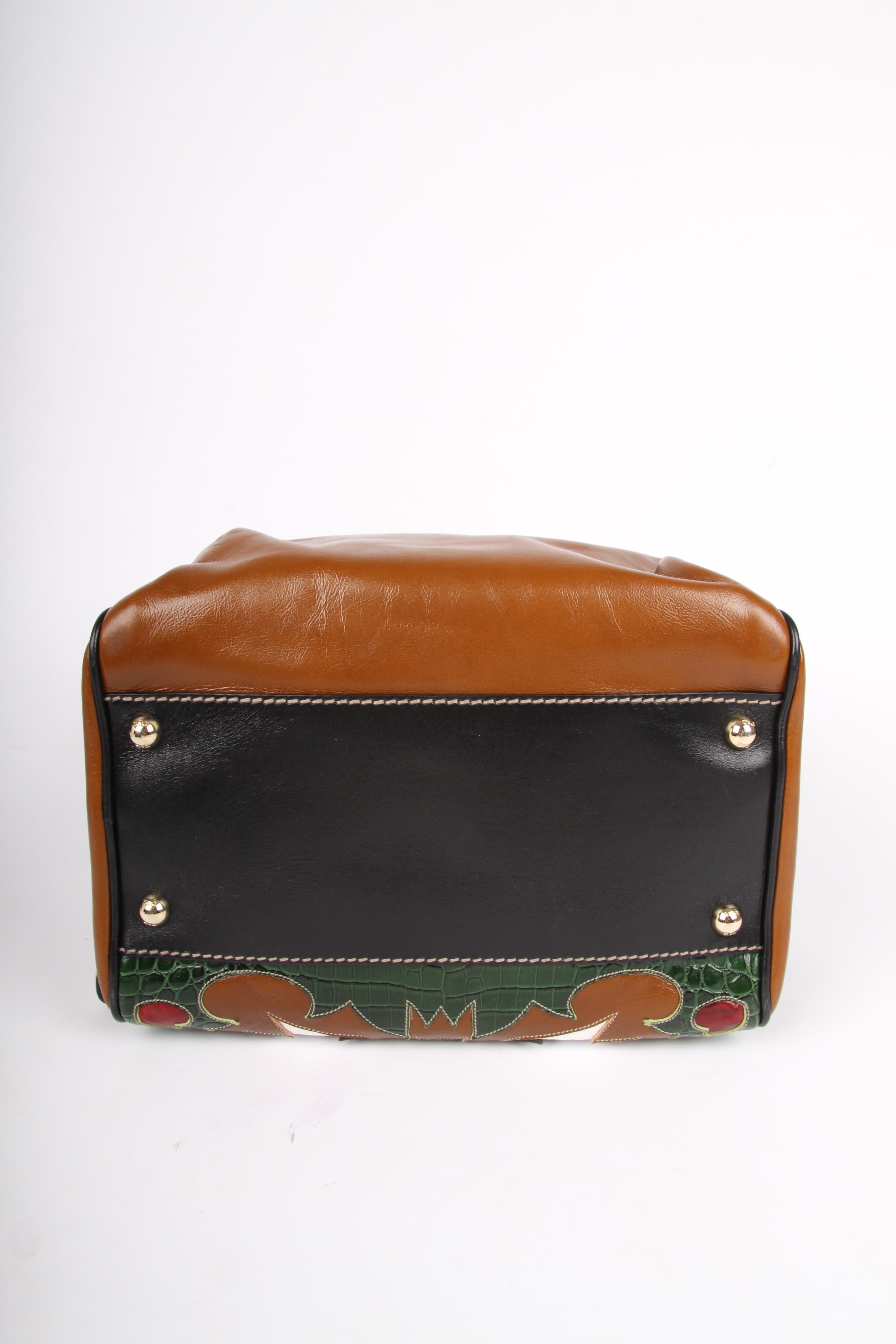 The famous Lily Bag by Dolce & Gabbana in Rodeo style.

The foundation is made of cognac coloured leather, top closure with as much as five gold-tone zipper. The front is very special: beautifully stitched patchwork with the picture of an eagle and
