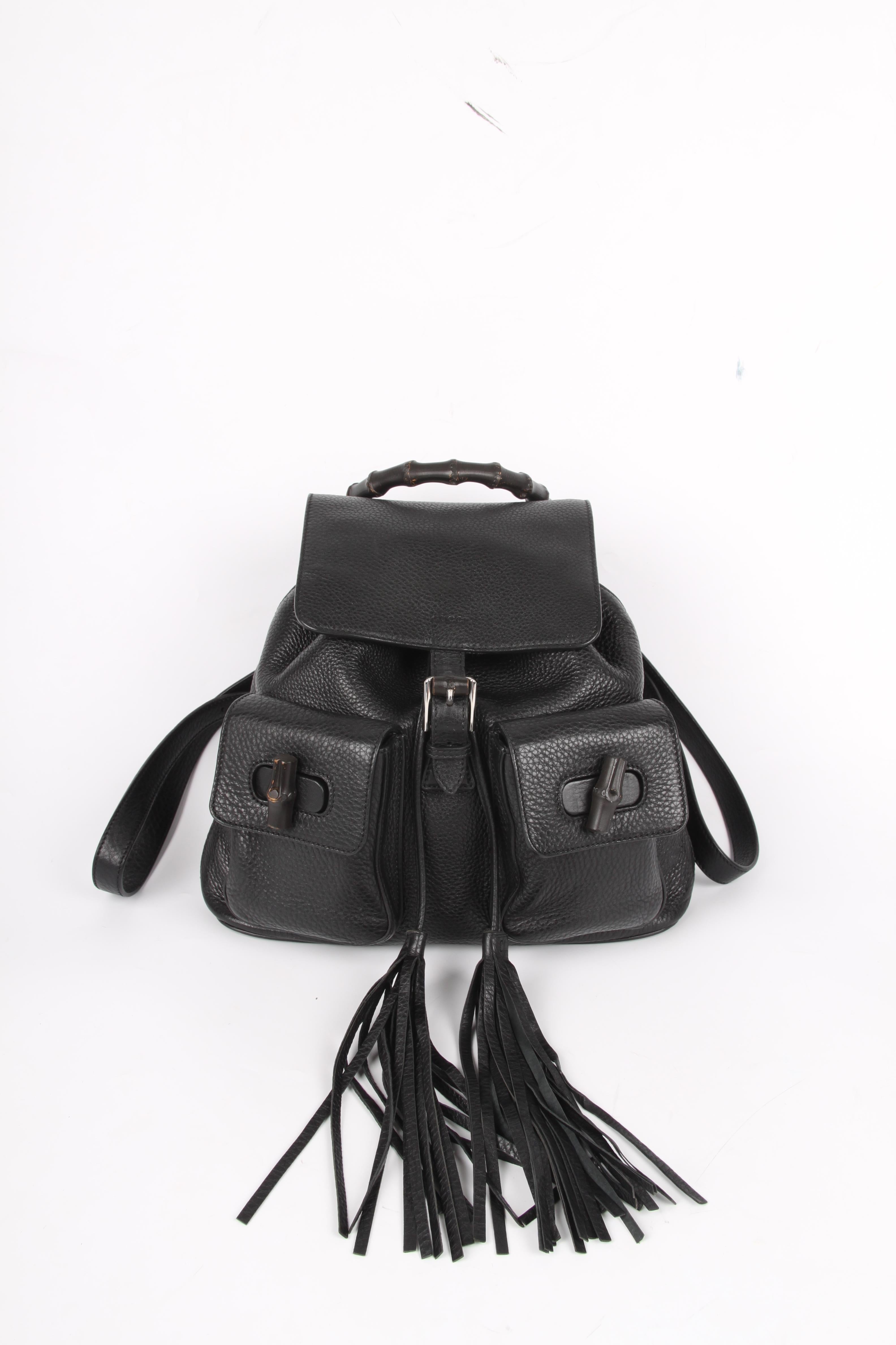 Black Gucci backpack in a compact size with black bamboo detailing and silver-tone hardware.

Crafted from black calfskin leather with a visible grain. On top you will find a black bamboo handle, the bag has drawstring closure underneath the flap.