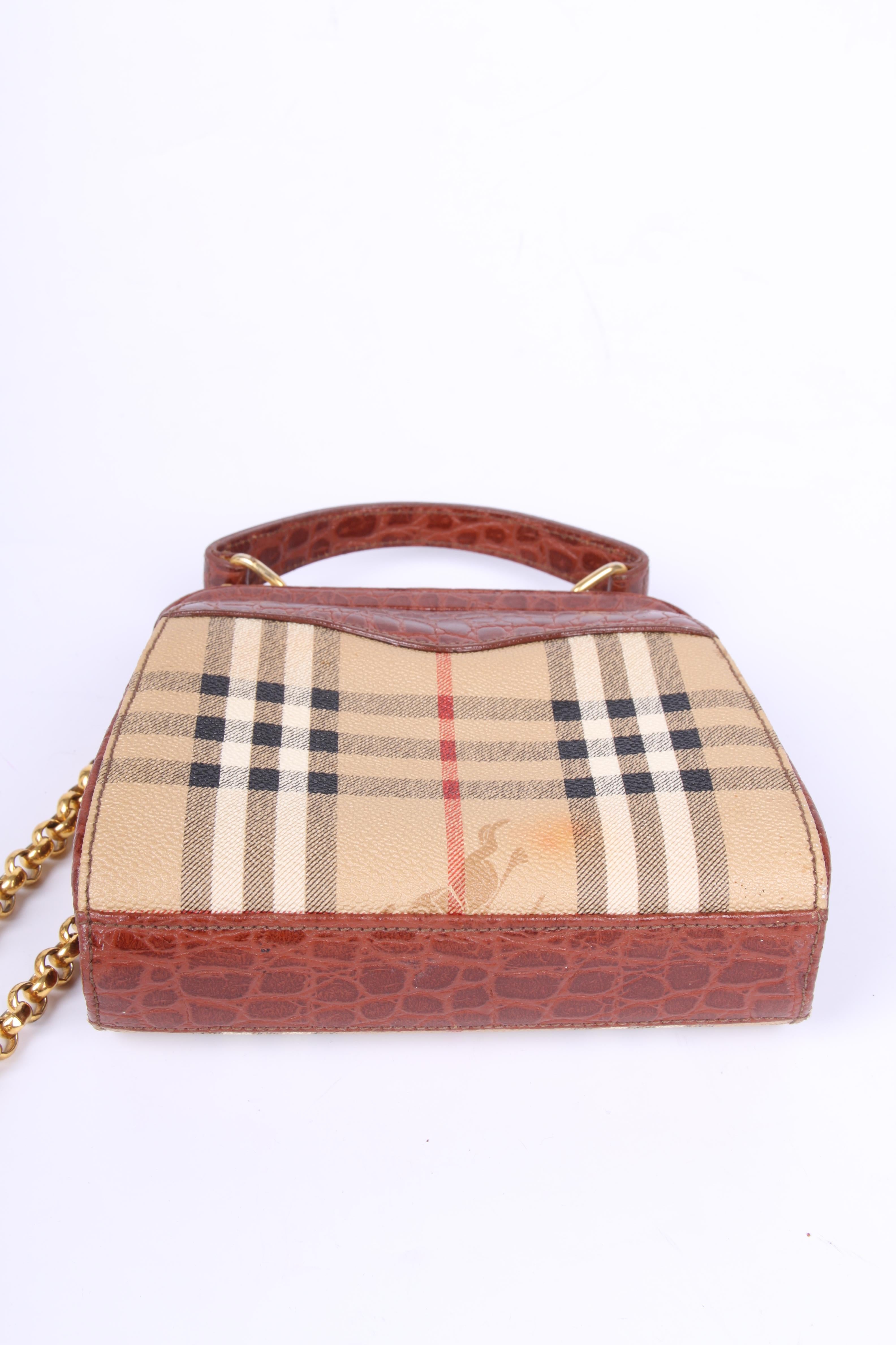Vintage crossbody bag by Burberry. Adorable!

This little model is of course embellished with the famous Burberry checks in beige, black, white and red. Top closure with a gold-tone push lock, a Burberry plaque at the front. Garnished with brown