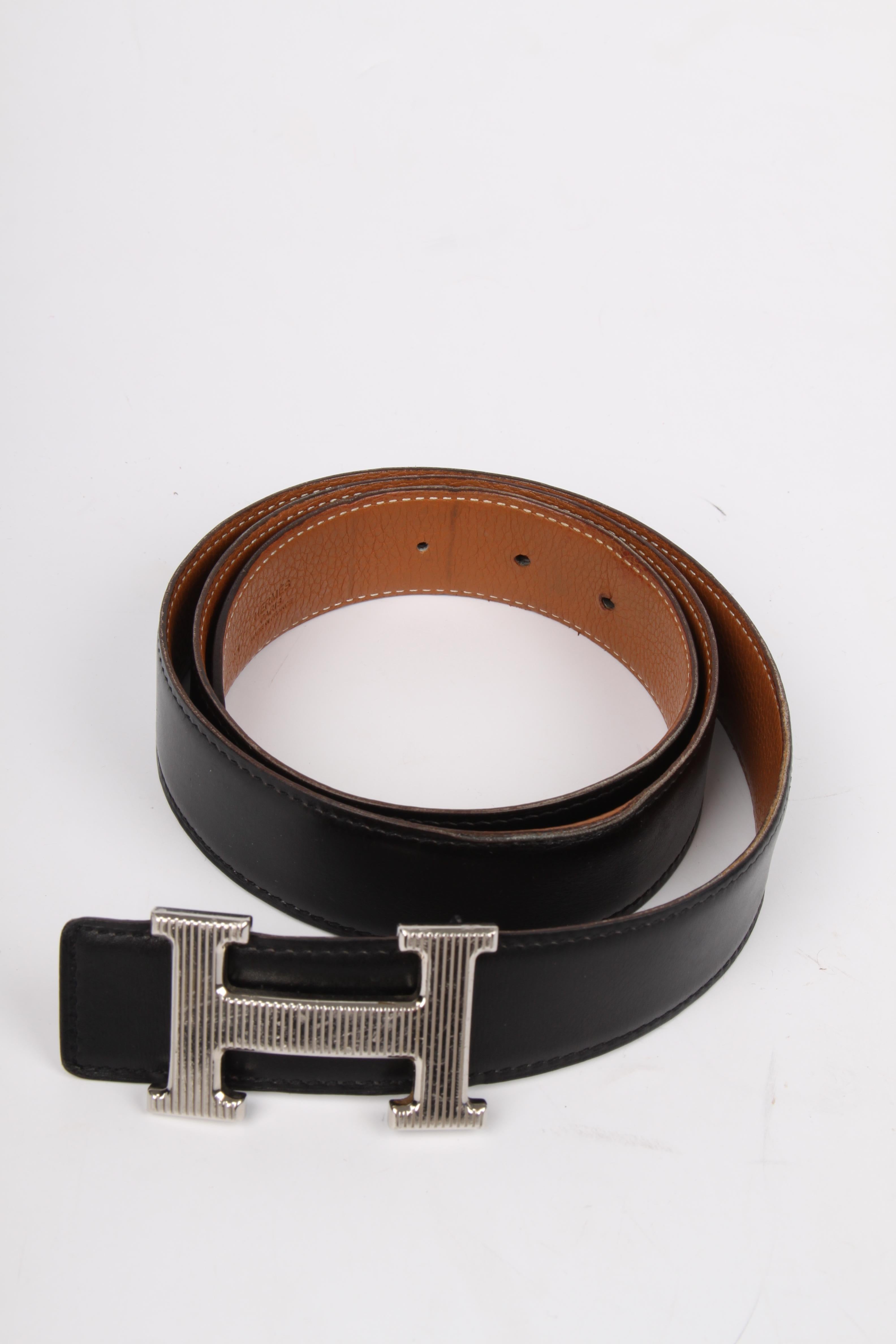 The welknown 'H' belt by Hermès, this one is reversible!

One side is crafted from black leather, the other side is brown. Length of the belt is 95 centimeters, 3 centimeters wide, embossed with stamp L. The silver-tone H buckle has vertical stripes