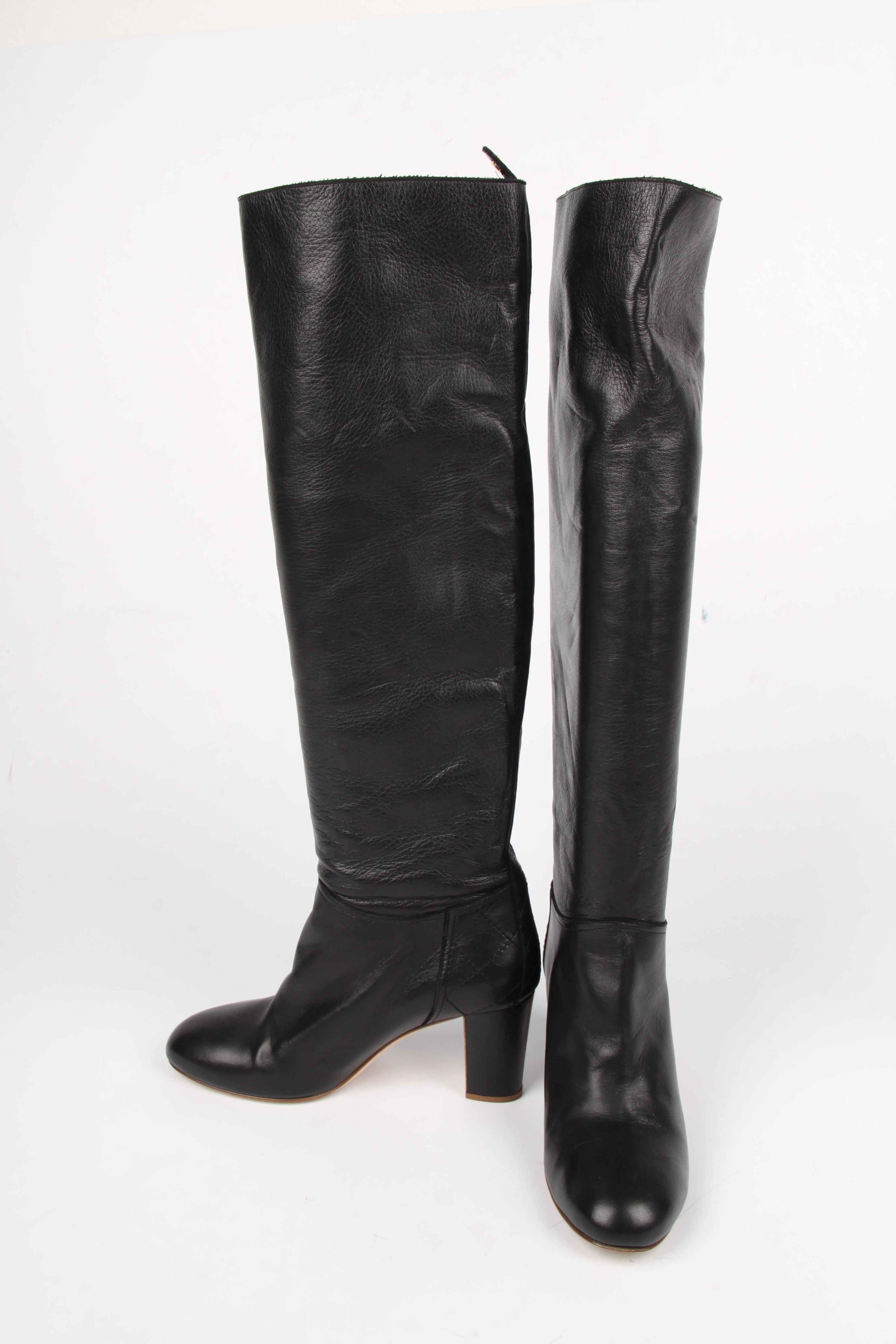 Knee-high pair of boots by Chanel in black leather, fantastic!

An almond shaped toe and sturdy heel that measures 7,5 centimeters, no platform. On the back a quilted detail and on top of the boot a tab with CC logo. No zippers in the 50 centimeters