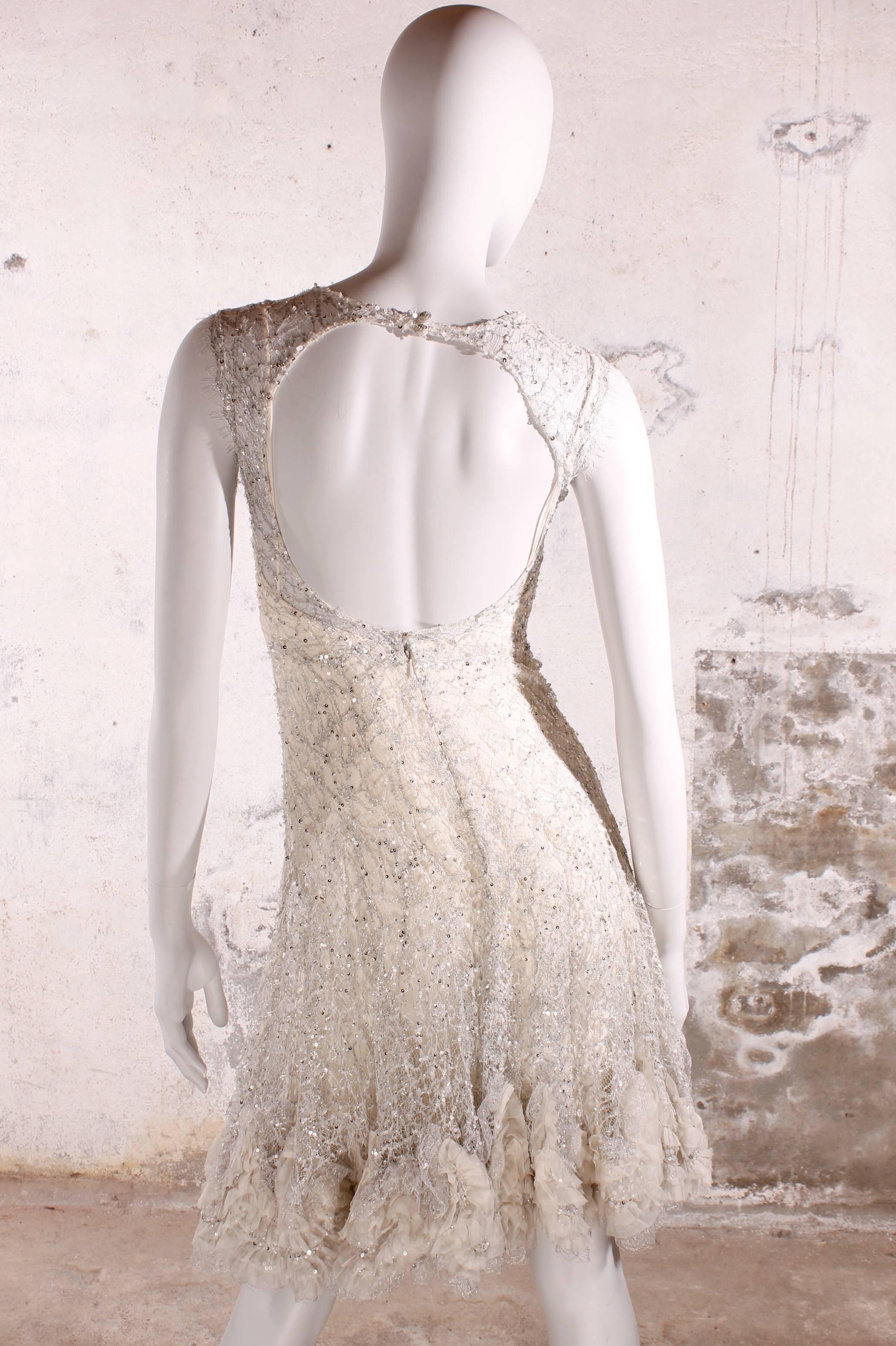 Fantastic Elie Saab haute couture evening dress/cocktail dress in diaphanous white lace covered with silver sequins. Very very exclusive!

At the hem a ruffle trim in silk and a large off-white silk bow at the front. Small spaghetti-straps, a layer