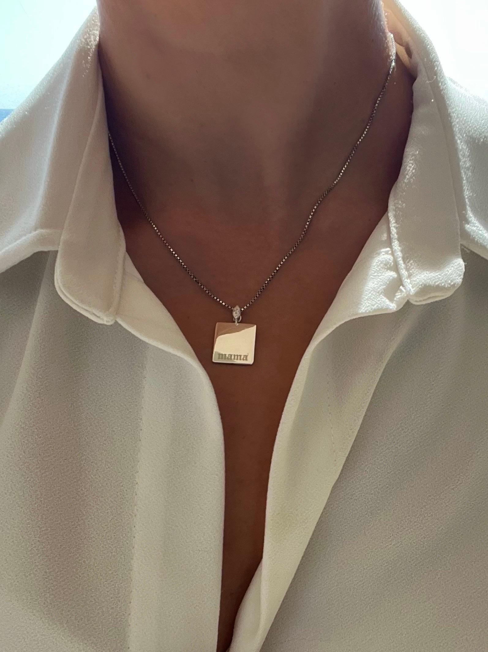 A custom Series of Eleven sterling silver dog tag pendant featuring a stunning floating moissanite stone with gothic style “mama” engraving. Paired with a sterling silver box chain. Designed to celebrate the stylish mama, the new mama, and the