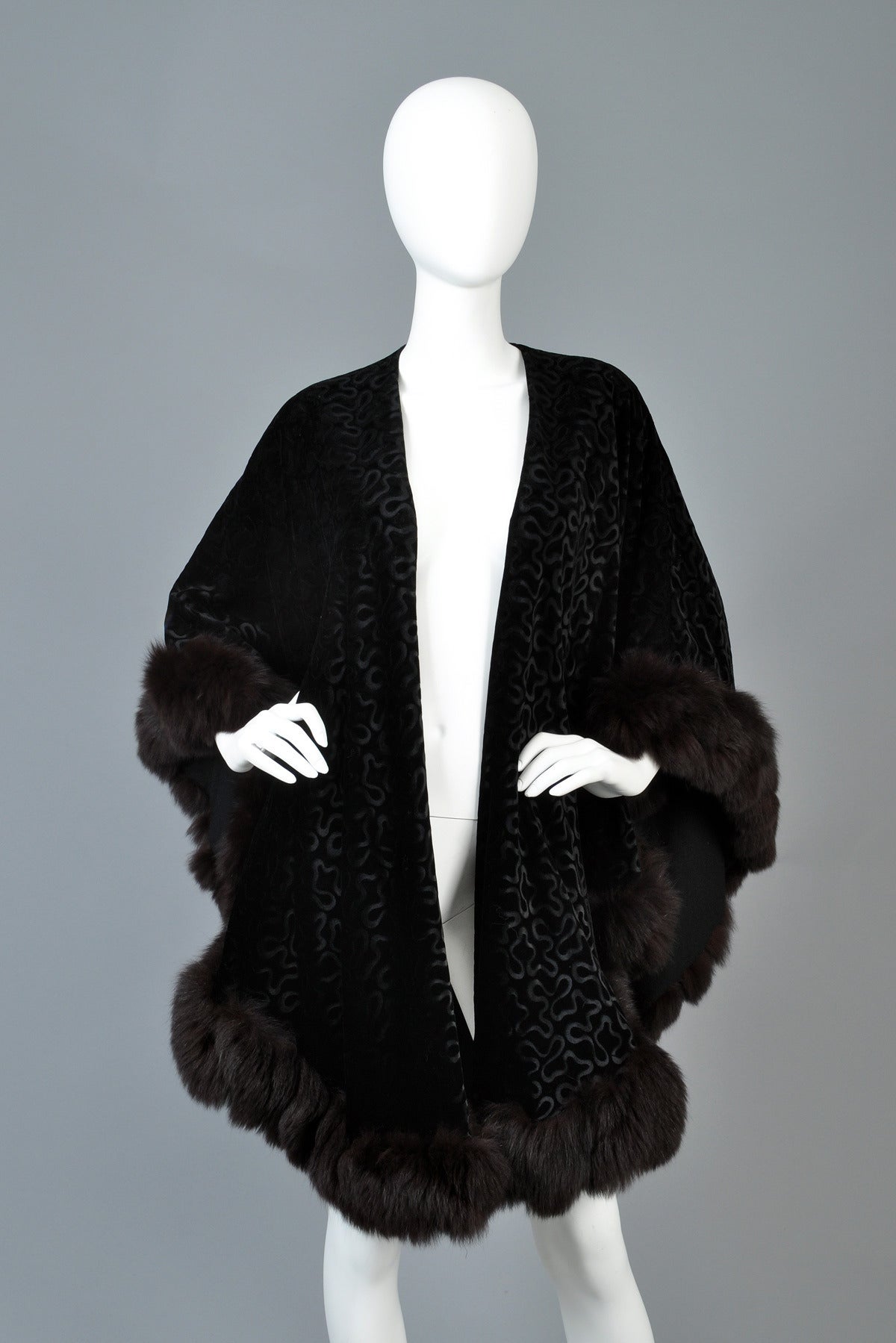 Fabulous 1980s Adrienne Landau textured velvet cape with fox fur trim. Incredible piece! Ultra draped black velvet with textured swirls running throughout. Long black dyed fox fur trim. Cozy wool flannel lining.  Designed to be worn open. Excellent