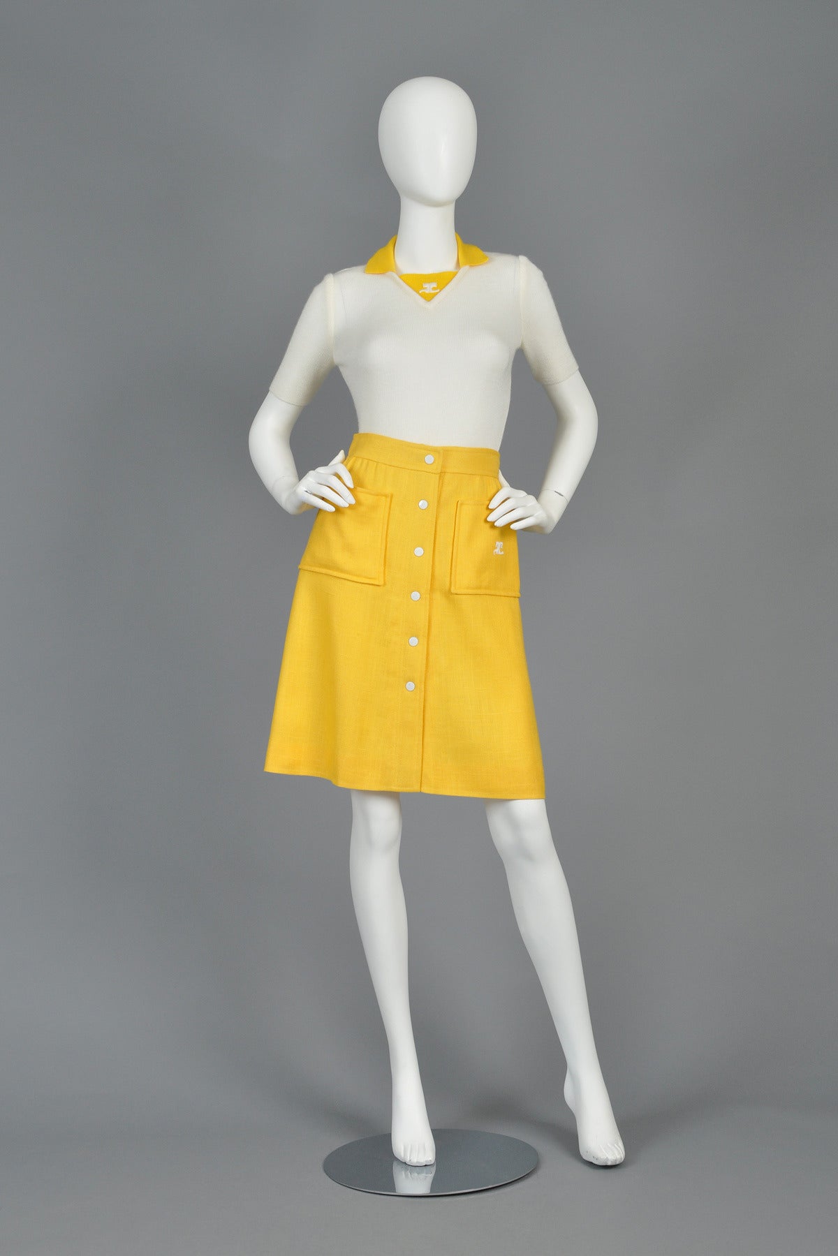 Classic Courrèges! Vintage 1960s skirt by Andre Courrèges. Oversized pockets with Courrèges logo. Snap front with contrasting white buttons. Fantastic bright yellow linen-textured rayon. Numbered Courrèges mainline label + Bonwit Teller tag.
