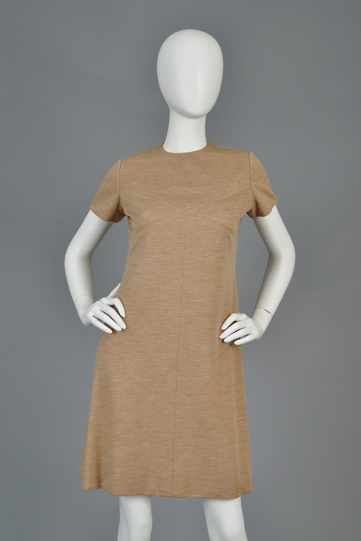 Super adorable 1960s space age inspired wool mini dress by Bill Blass. Such a great little piece! Classic a-line construction with ultra high neckline, capped sleeves and inserted diamond details around the bust. Lovely mocha colored melange wool.