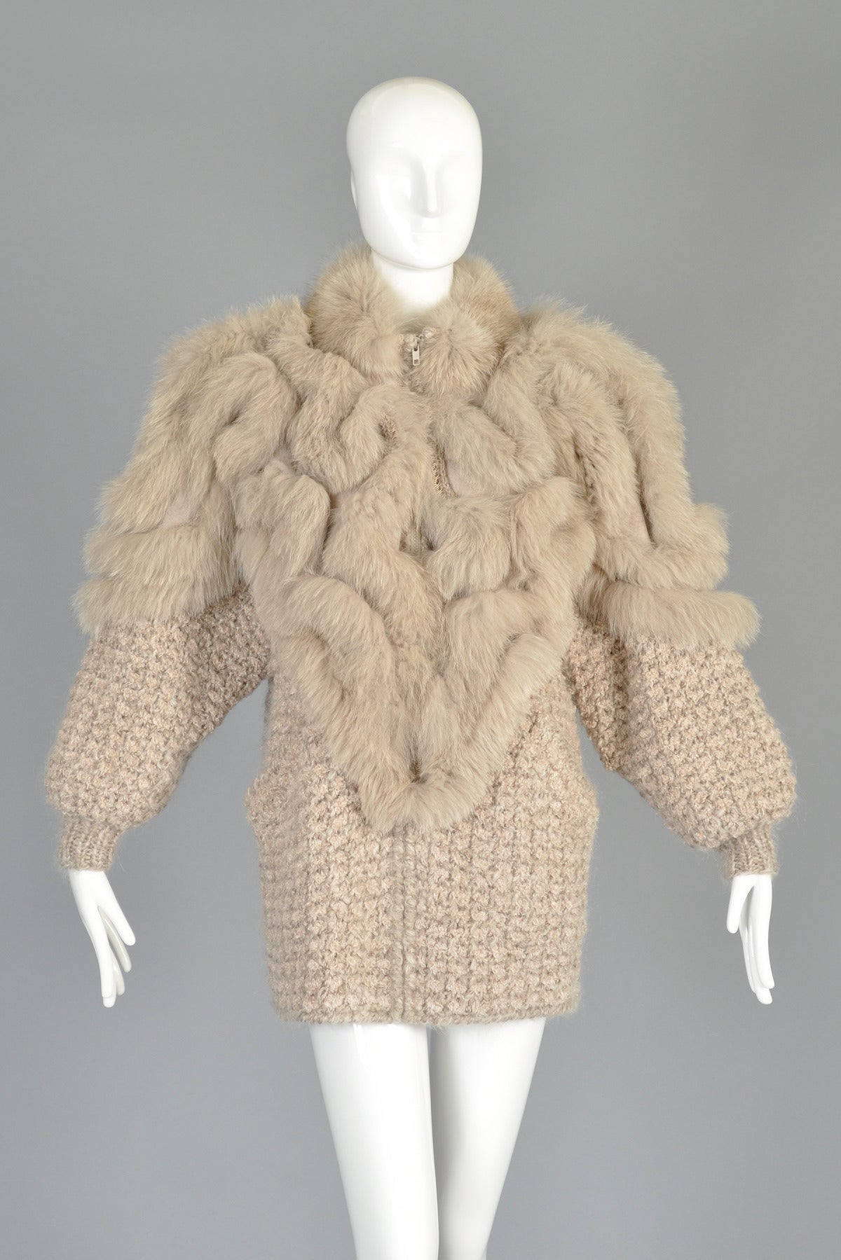 Superb 1980s avant garde knit cocoon coat with fox fur shoulders. Delicious pale cappuccino color. Ultra heavy mohair/wool/acrylic blend knit body with zip front and besom pockets. Genuine suede panels surround the shoulders, front and back and are