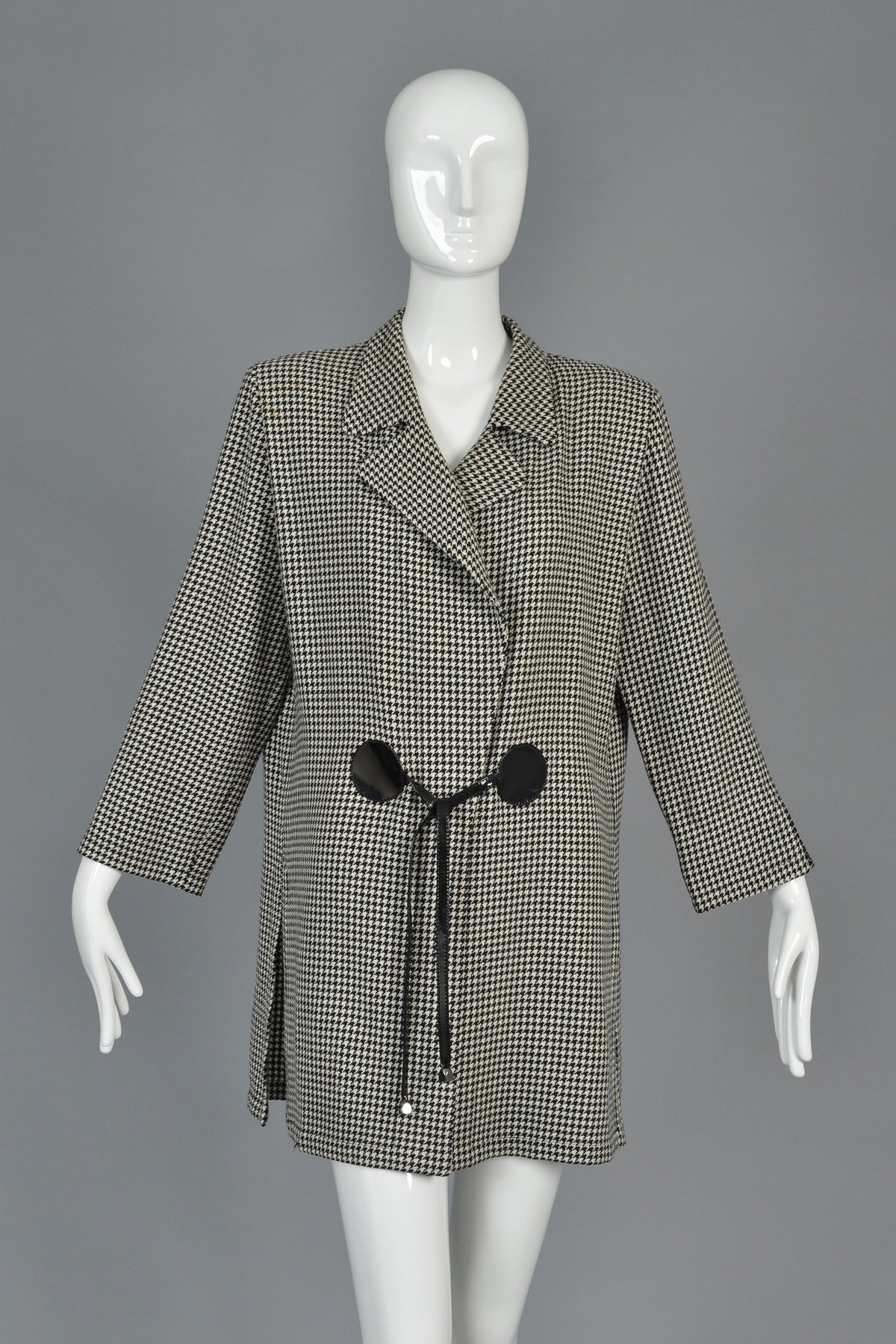 Beautiful vintage 1990s haute couture hounstooth jacket by Pierre Cardin. Circa 1993. Incredible classic Cardin avant garde construction featuring his signature vinyl circle ties at the waist. Oversized shoulders with slightly nipped waist and huge