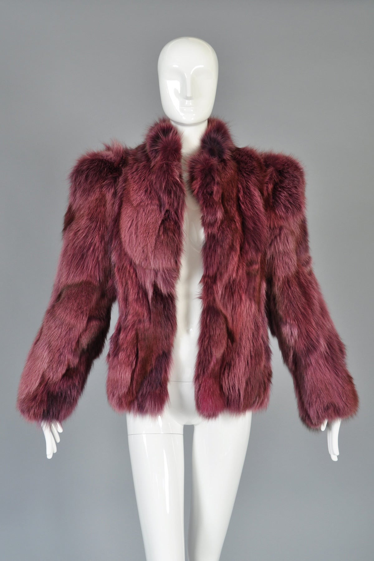 Superb vintage 1980s raspberry colored fox fur coat. INCREDIBLE piece in an incredible color! Raspberry patchwork body with high neckline, massive shoulders and super long sleeves. Has very padded, oversize shoulders that give this 1980s piece a