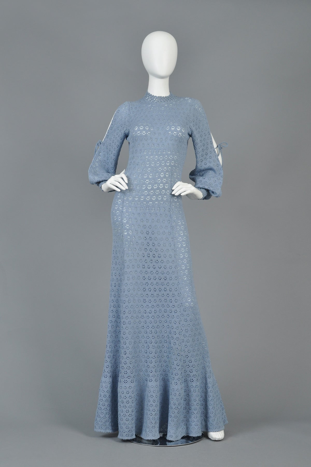 Incredible 1970's open weave knit dress. AMAZING cornflower blue color with tiny open weave florals that almost look crocheted. Ultra slinky fit with flared mermaid hem and gorgeous open bishop sleeves that tie around the elbow. Elbow ties can be