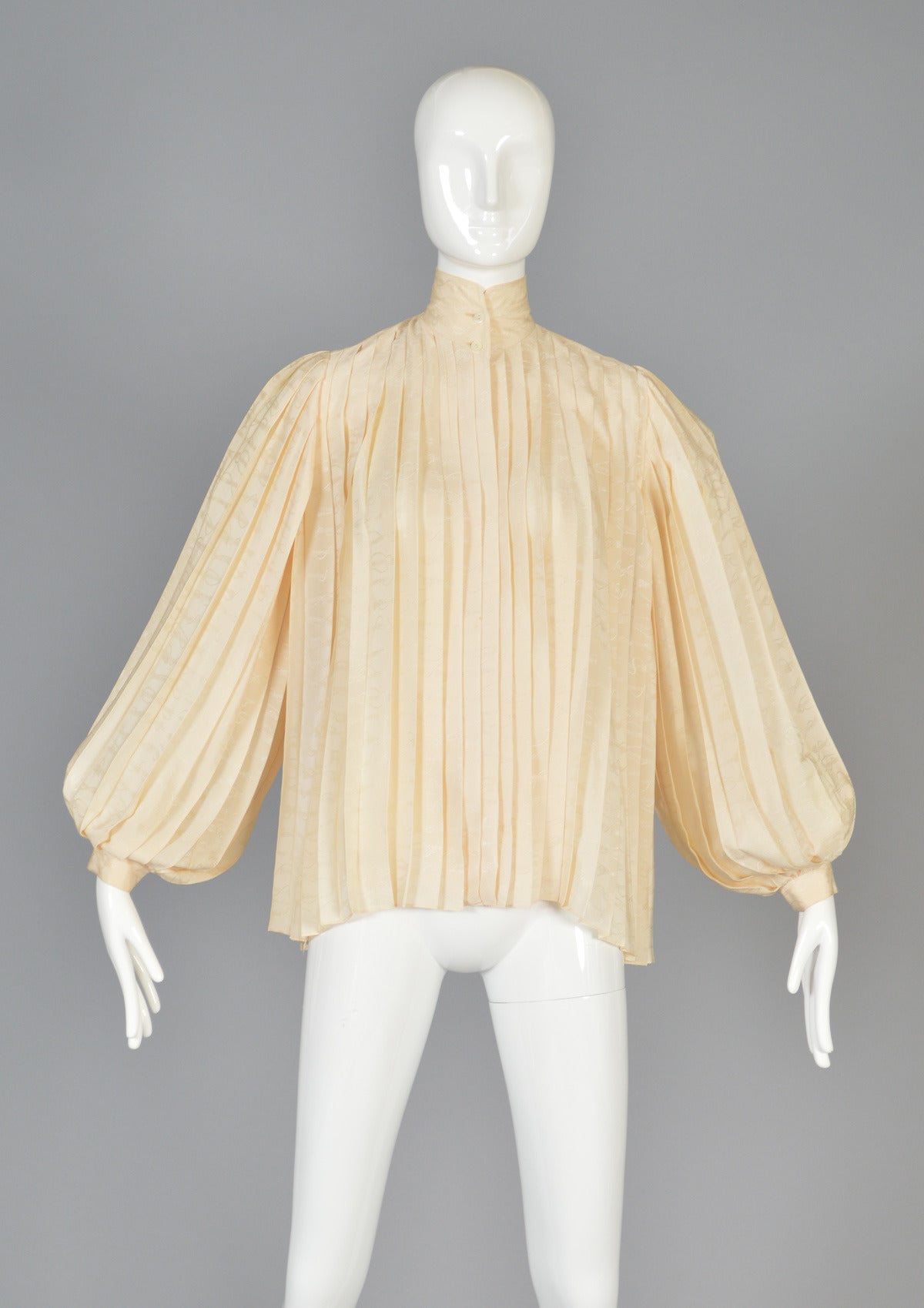 Spectacular late 70s/early 80s silk blouse by Gucci. Seriously one of THE BEST blouses we've come across! Stunning shimmery ivory silk has the classic Gucci rope and tassel motif woven throughout the fabric. The pleated body has a full 360 sweep