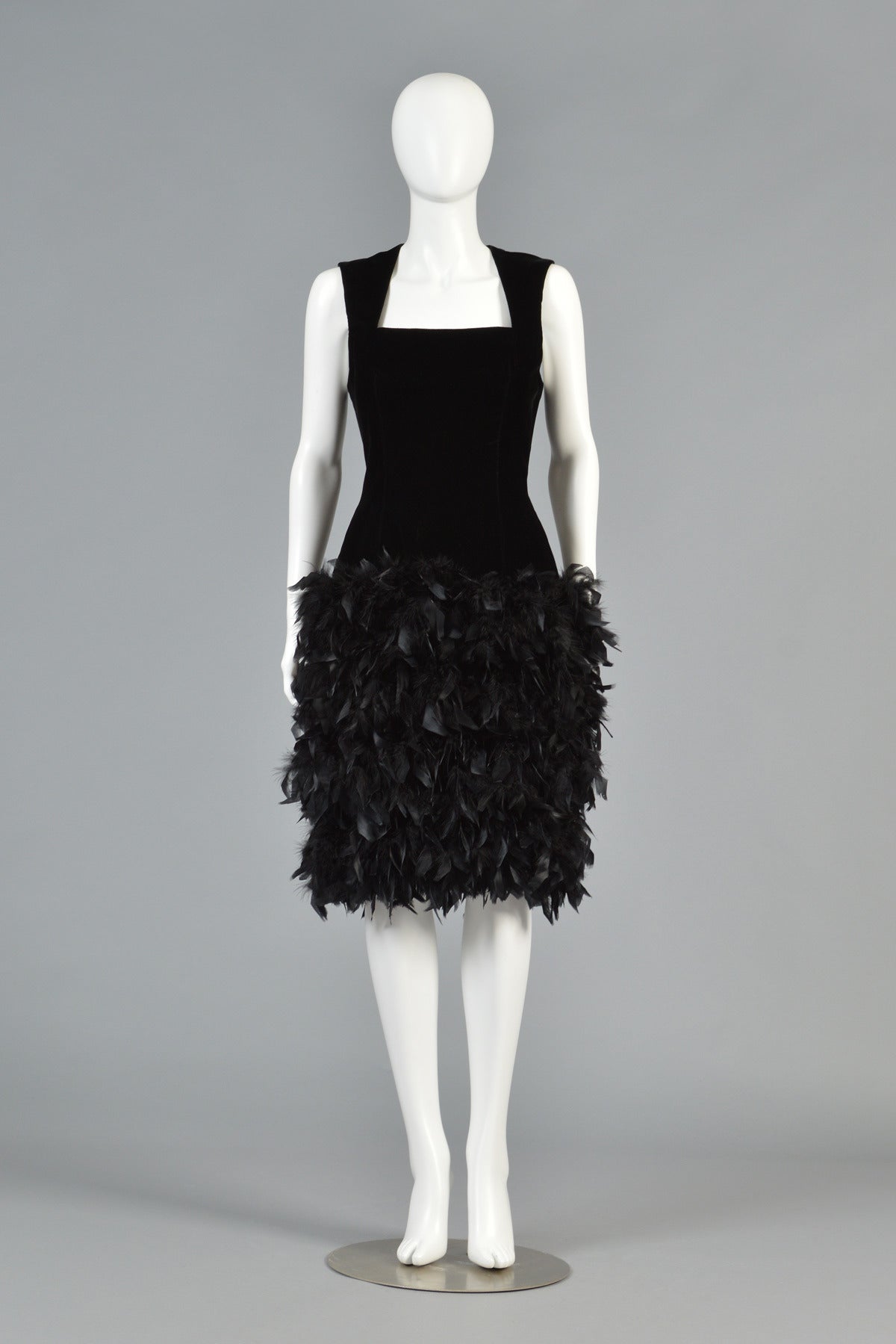 Truly awesome early 1990s vintage black velvet cocktail dress with feathered skirt! Absolutely killer piece. Amazing squared neckline with wide straps + nipped waist. The absolutely MASSIVE feathered skirt gives the piece an incredible silhouette.