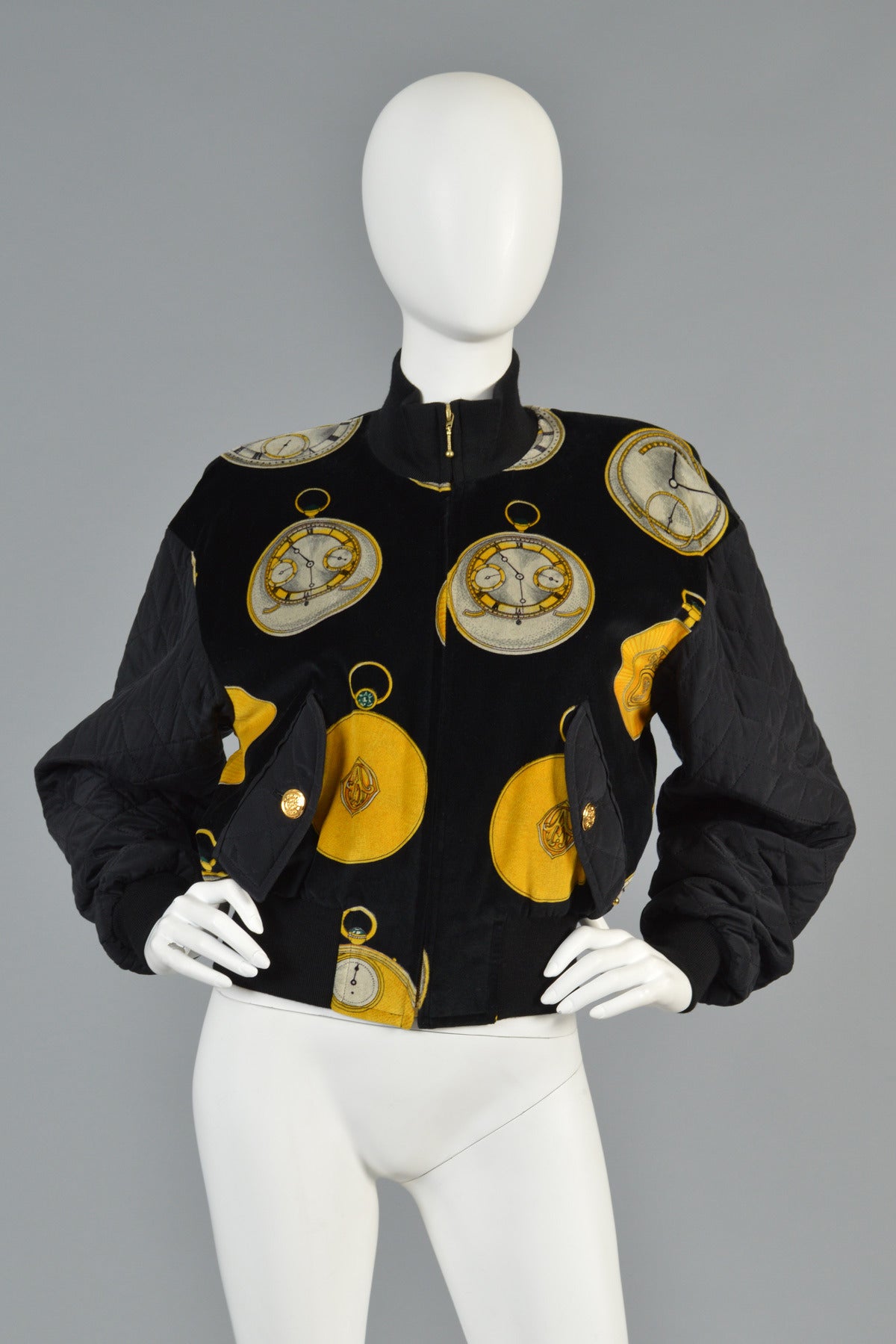 Super sweet vintage 1980s Escada bomber jacket. Black velvet body with graphic black/white/gold pocket watch print. Quilted silk sleeves + flap pockets. Zip front. Excellent condition. 

MEASUREMENTS
Bust: 40