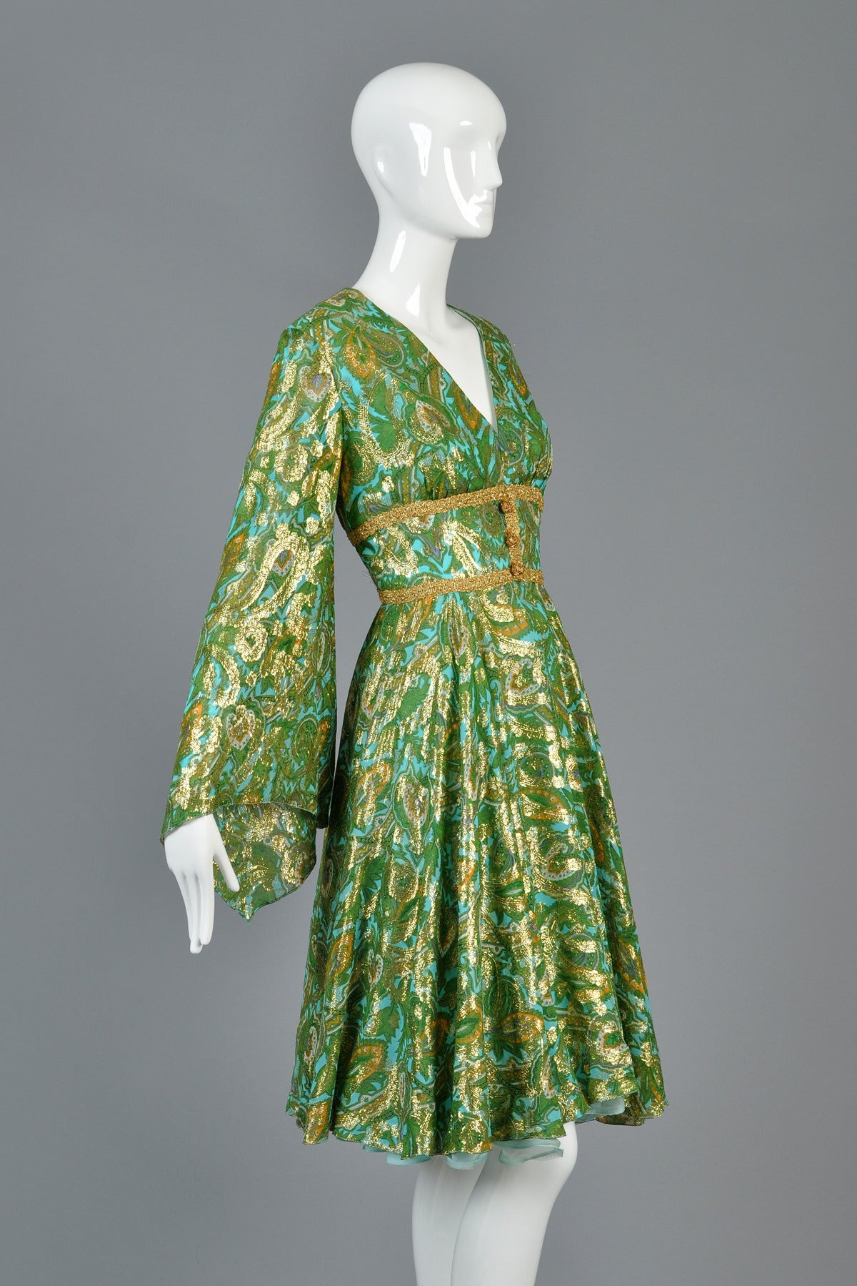 Absolutely lovely 1960s ethnic inspired dress by Roger Milot for Fred Perlberg.  Beautiful sky blue and emerald green metallic silk brocade dress. The PERFECT piece for any spring event! Plunging neckline with fitted bodice, flared skirt and huge