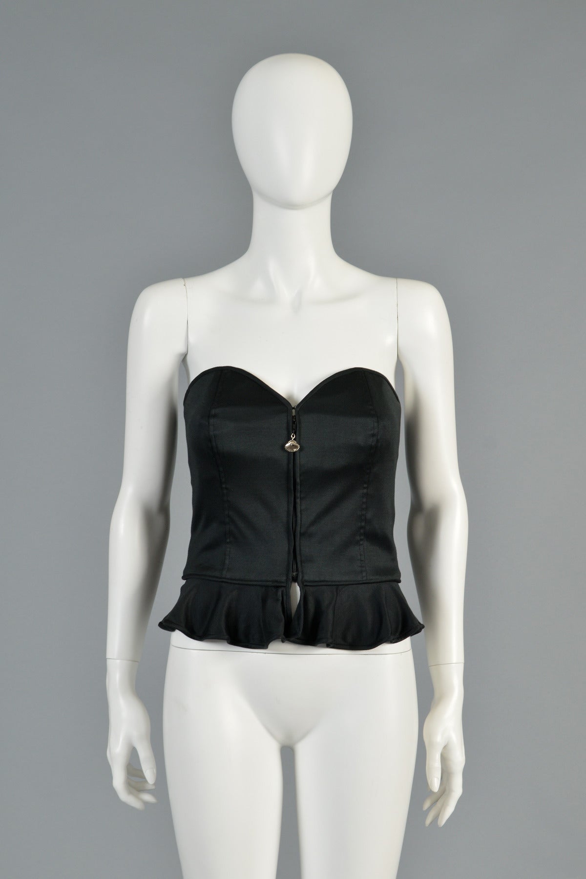 Super great 1980s bustier top by Emanuel Ungaro.  An excellent, versatile find that is sure to be a staple in any wardrobe! Sweetheart neckline with zip front, metal seashell zipper pull and the sweetest little peplum. Classic and chic. No material