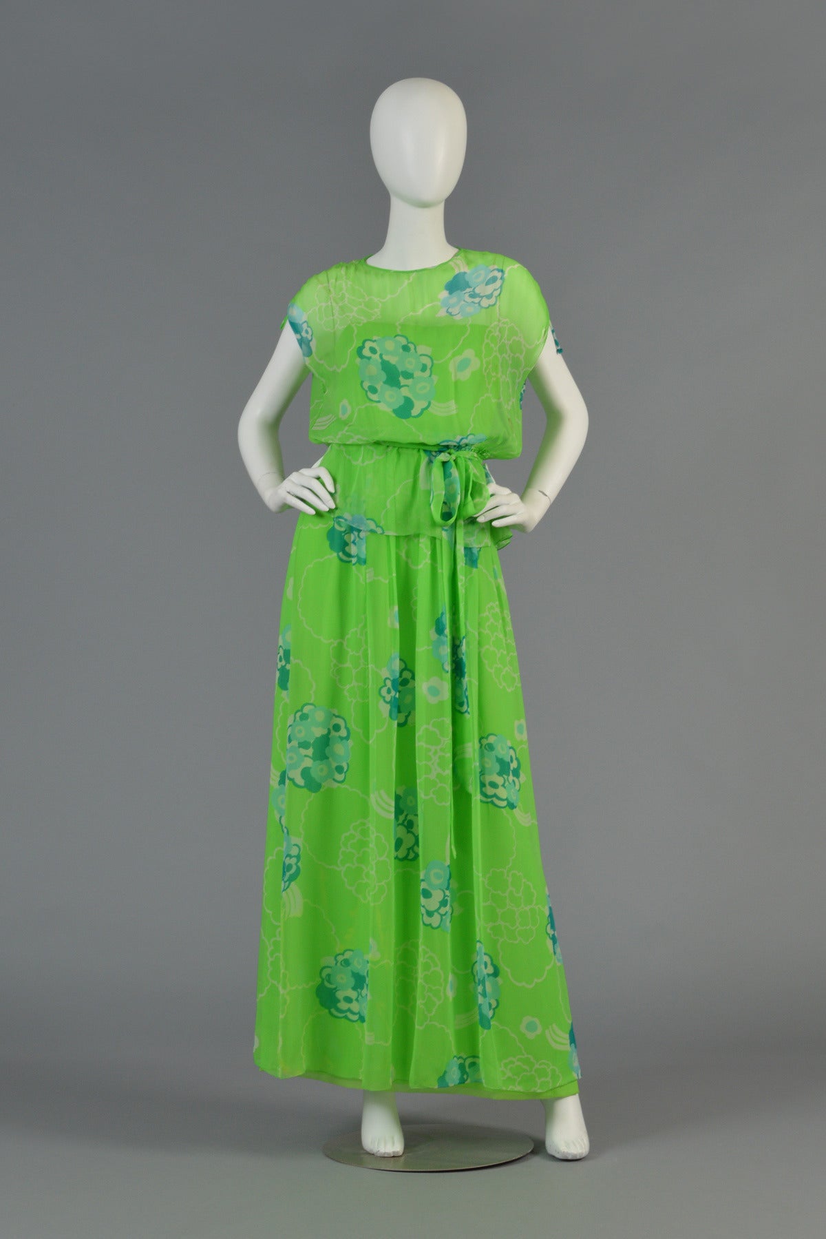 Fantastic vintage 1970s 3-pc silk chiffon floral gown by Adele Simpson. Incredible shade of green with graphic florals. Ensemble consists of full-length maxi gown with spaghetti straps, a sheer boxy/kimono-style top with elastic waist and a matching