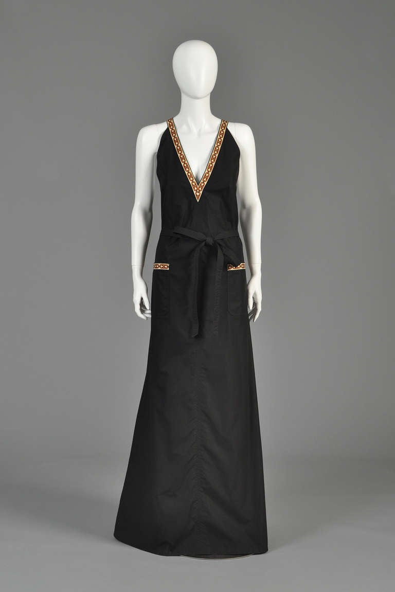 Killer 1970s Celine maxi wrap dress. Insanely hard to find and coveted piece! Black cotton body features classic wrap pattern with slight slit in the seam for low-waisted wrapping belt + flared skirt. Plunging neckline with massive pockets. Of